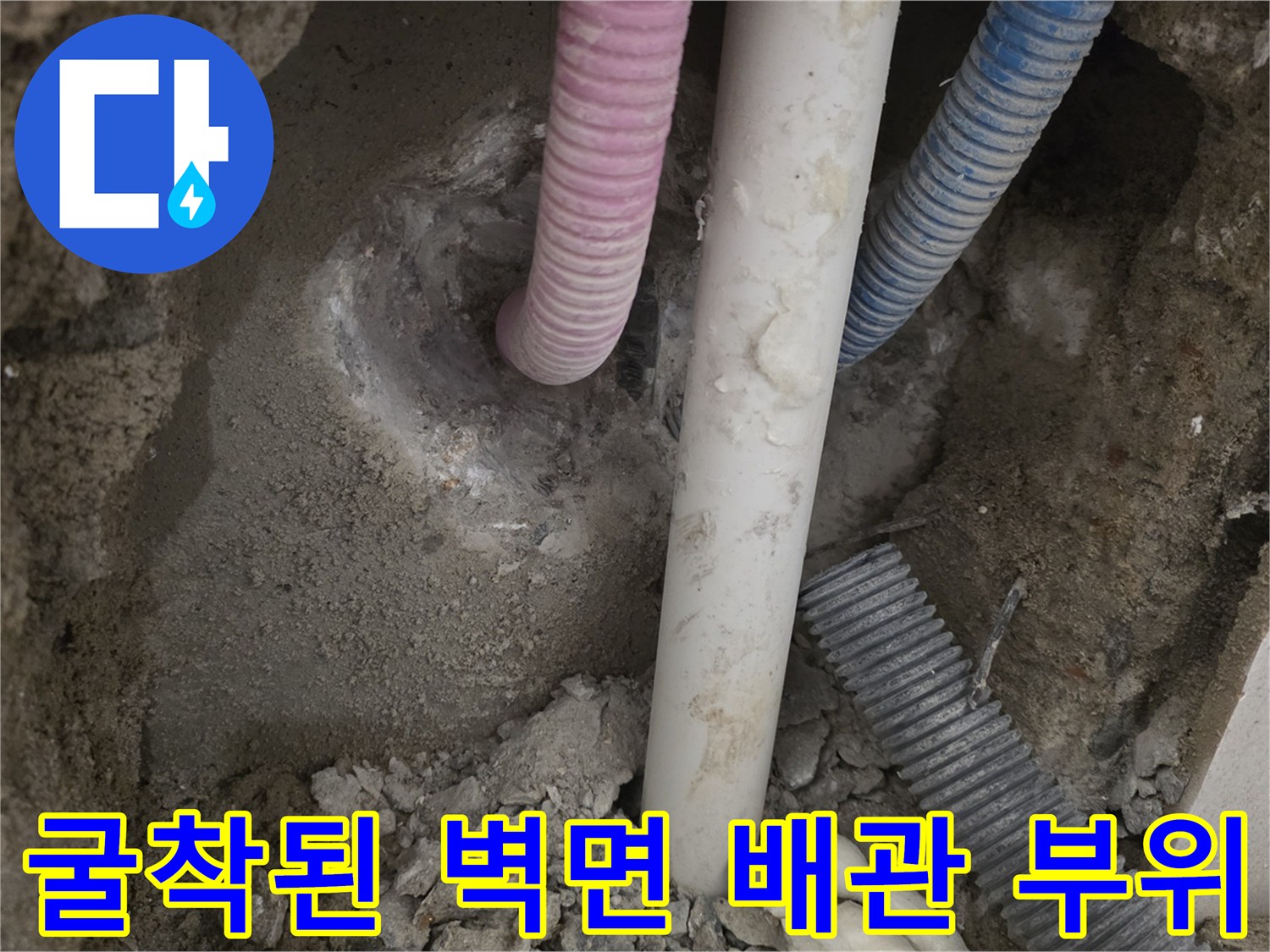 벽면 굴착 후 드러난 분홍색 및 흰색 배관 연결부