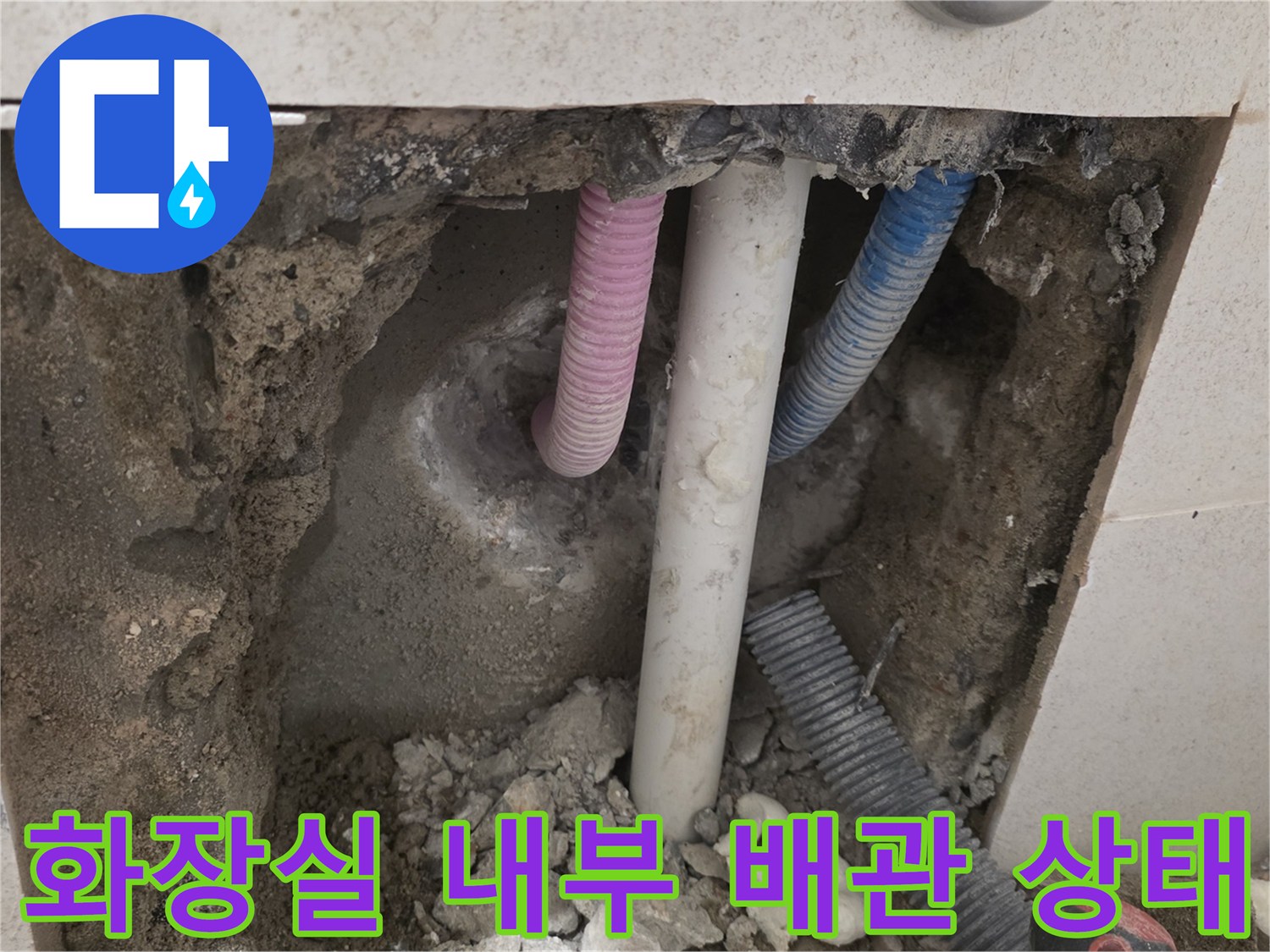 타일 굴착 후 드러난 화장실 벽면 내부의 분홍색 및 흰색 배관 모습