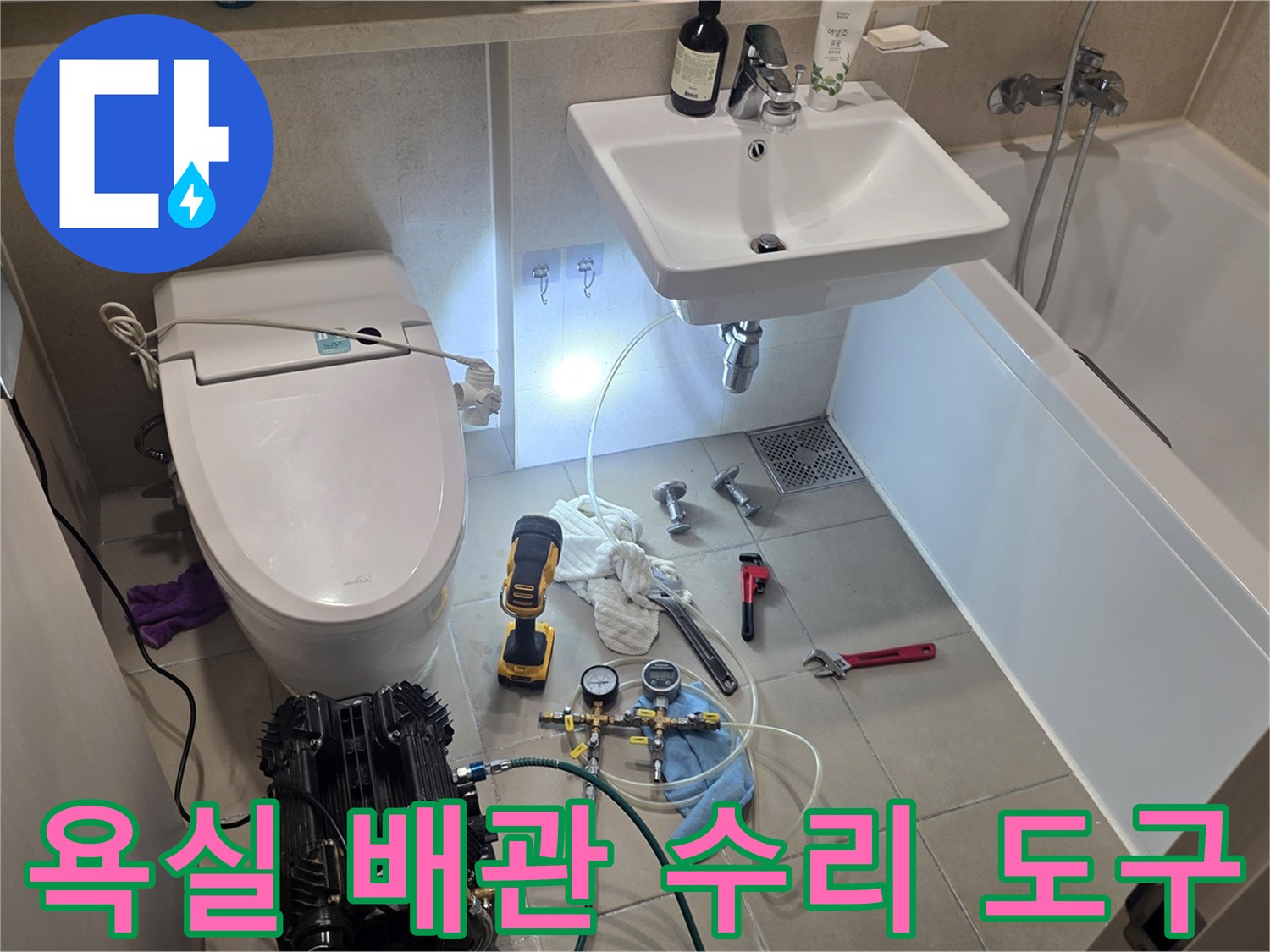 화장실 바닥에 놓인 누수 진단용 압력계와 각종 작업 공구들