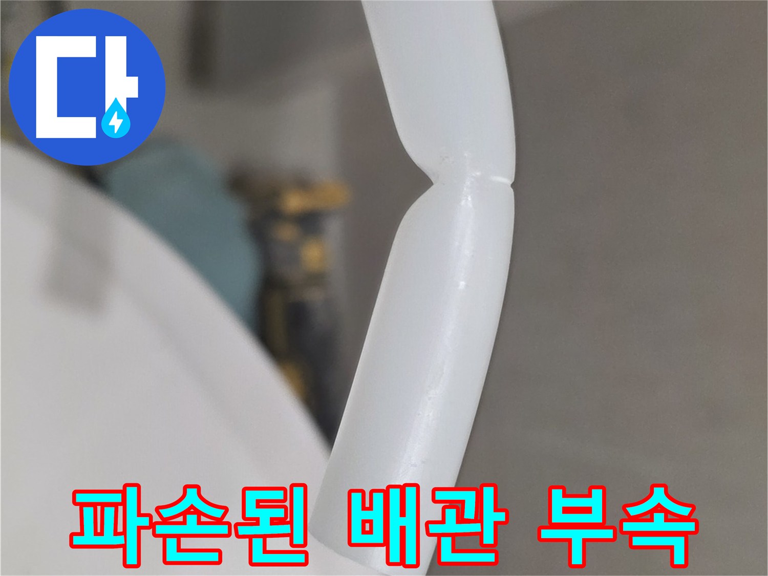 화장실 벽면 내부에서 제거한 파손된 하얀색 플라스틱 배관 부속