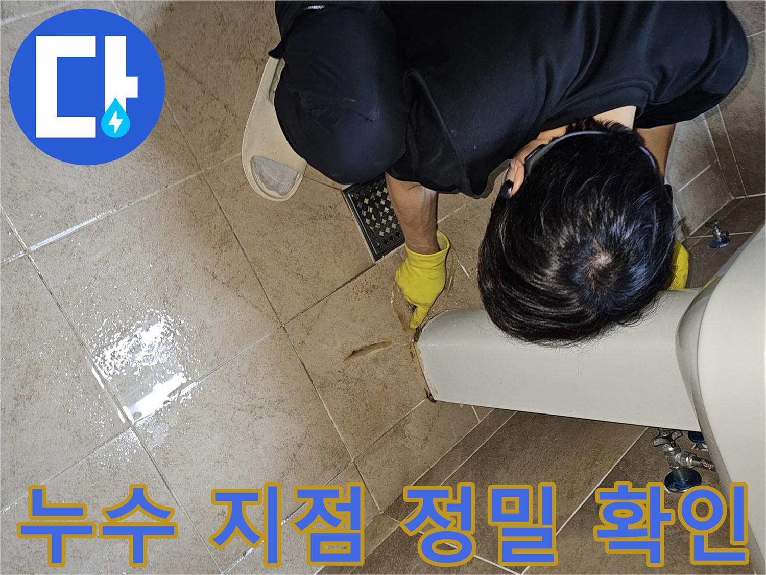 누수 전문가가-젖어있는 욕실 바닥 타일과-세면대 하단부를-집중적으로 살펴보며-누수 지점을 특정하고 있습니다