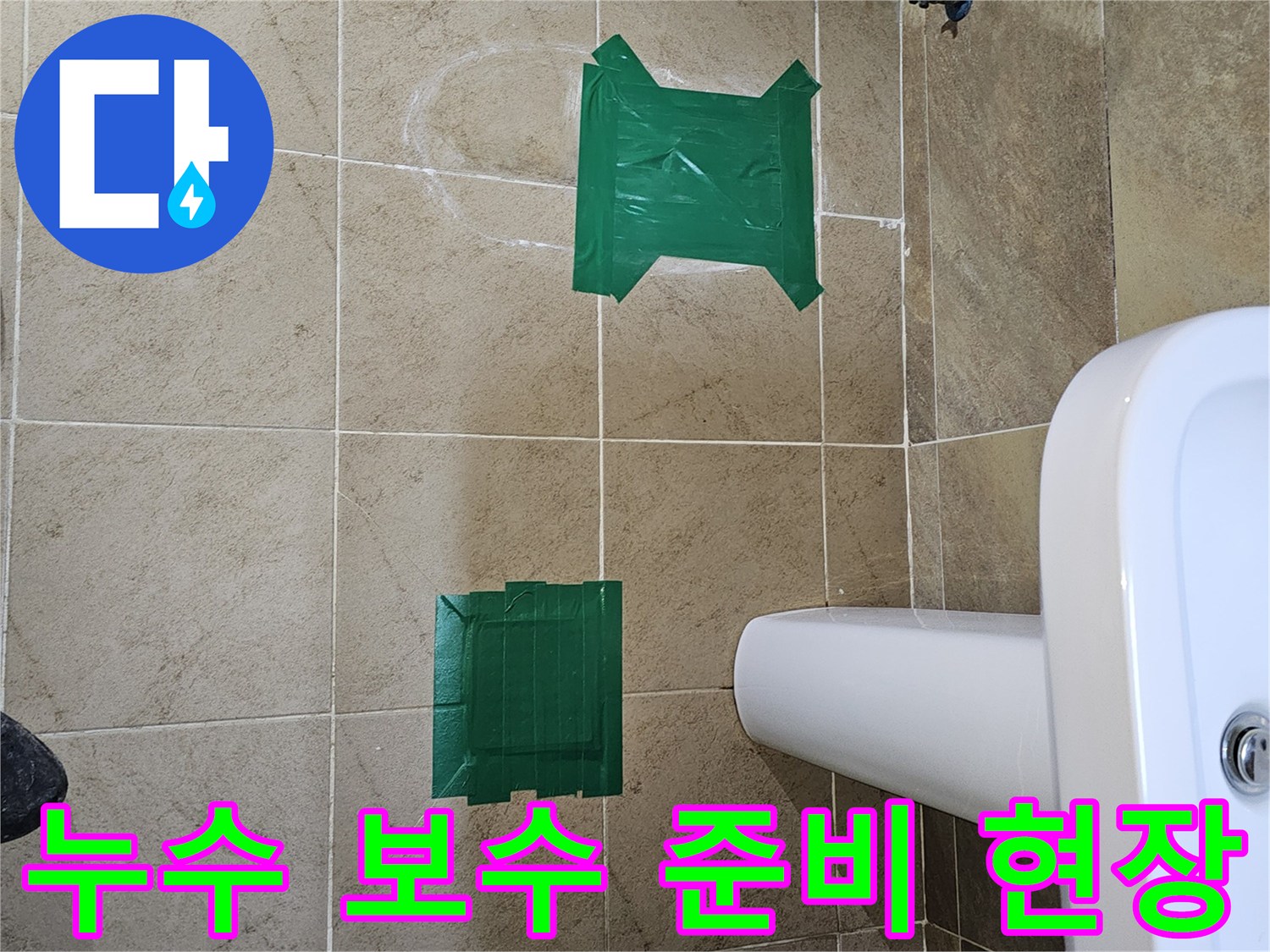 욕실 타일 바닥에 녹색 테이프로 표시된 누수 탐지 완료 지점-이제 보수 작업을 시작할 준비가 되었습니다.