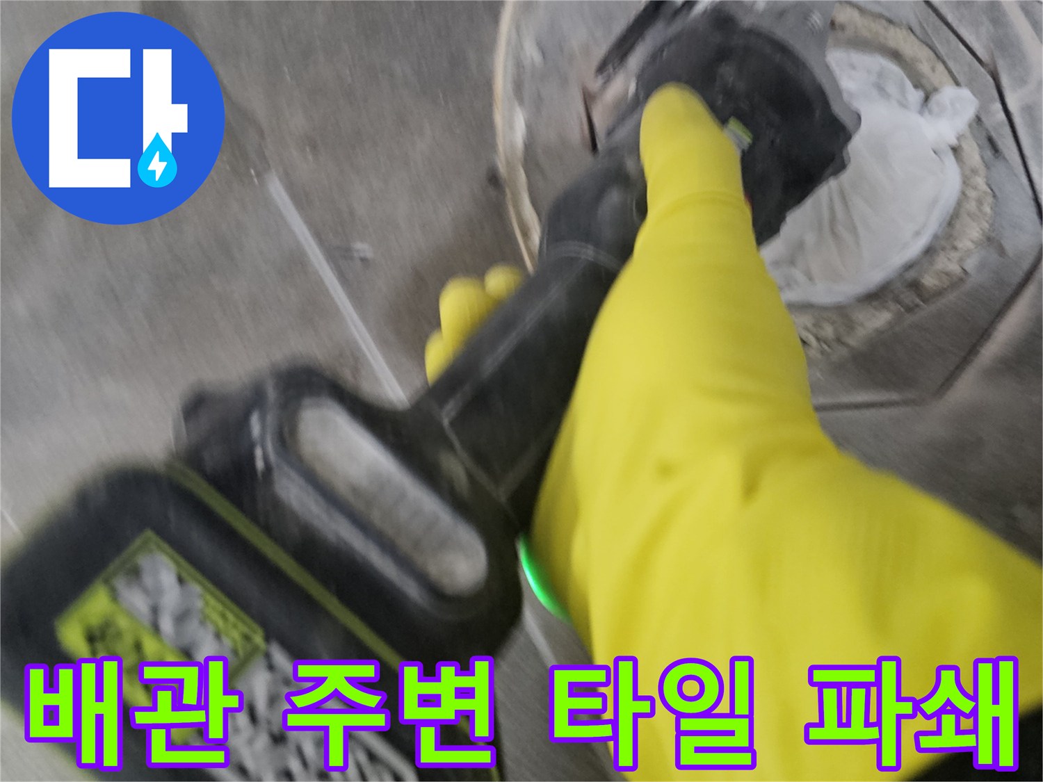노란색 보호 장갑을 착용한-전문가가-전동 공구로-배관 주변의-바닥 타일을-신중하게 파쇄하는 모습입니다.