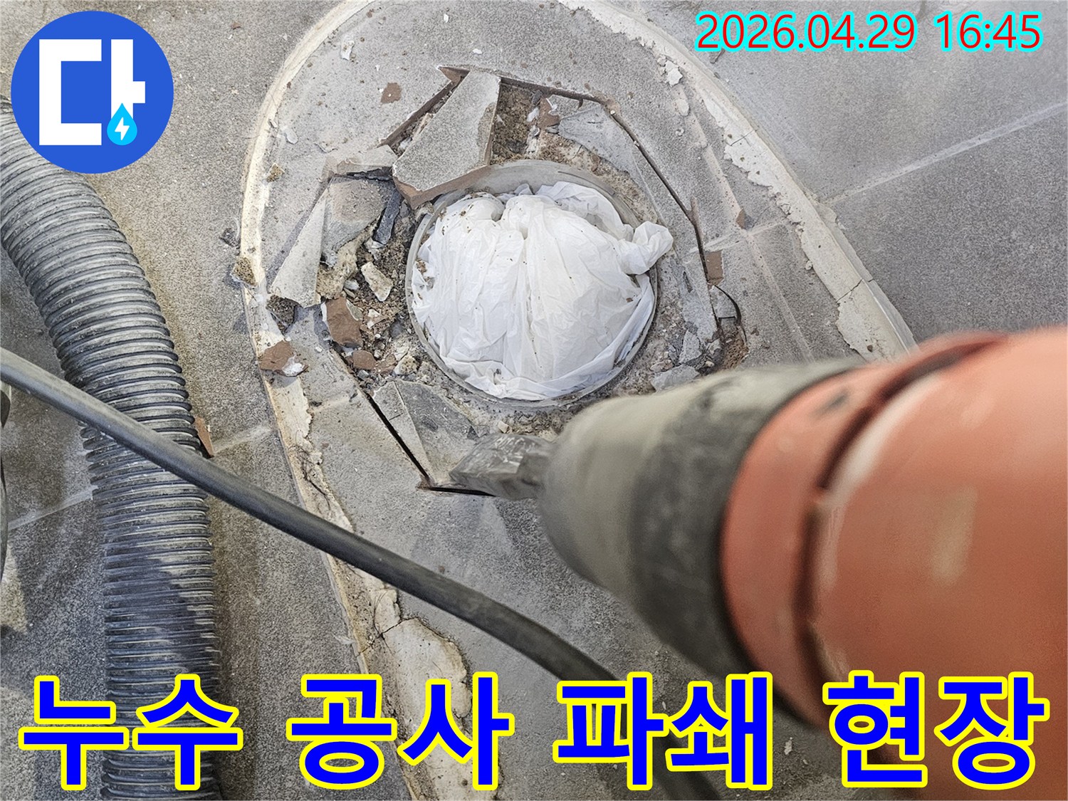 누수 원인 파악을 위해 바닥을 조심스럽게 파쇄하는 해머드릴 작업 현장입니다.