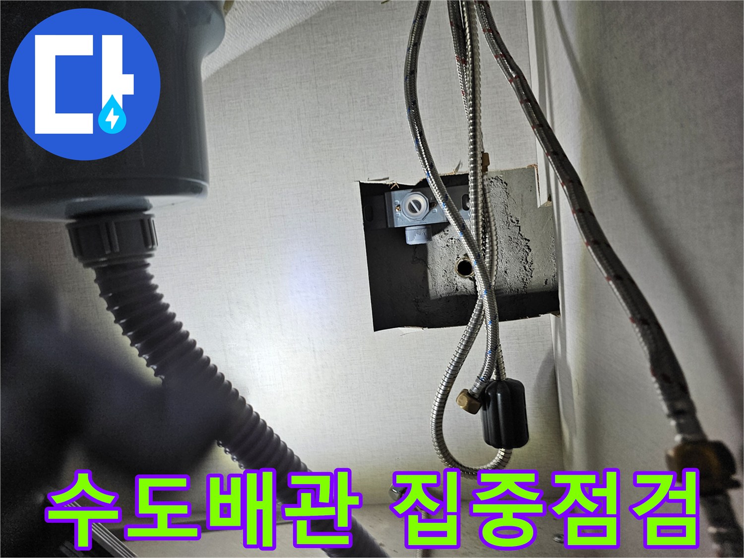 싱크대 하부장 내부의-수도 배관 연결 부위를-집중적으로 점검하며-누수 여부를-확인하는 장면입니다.