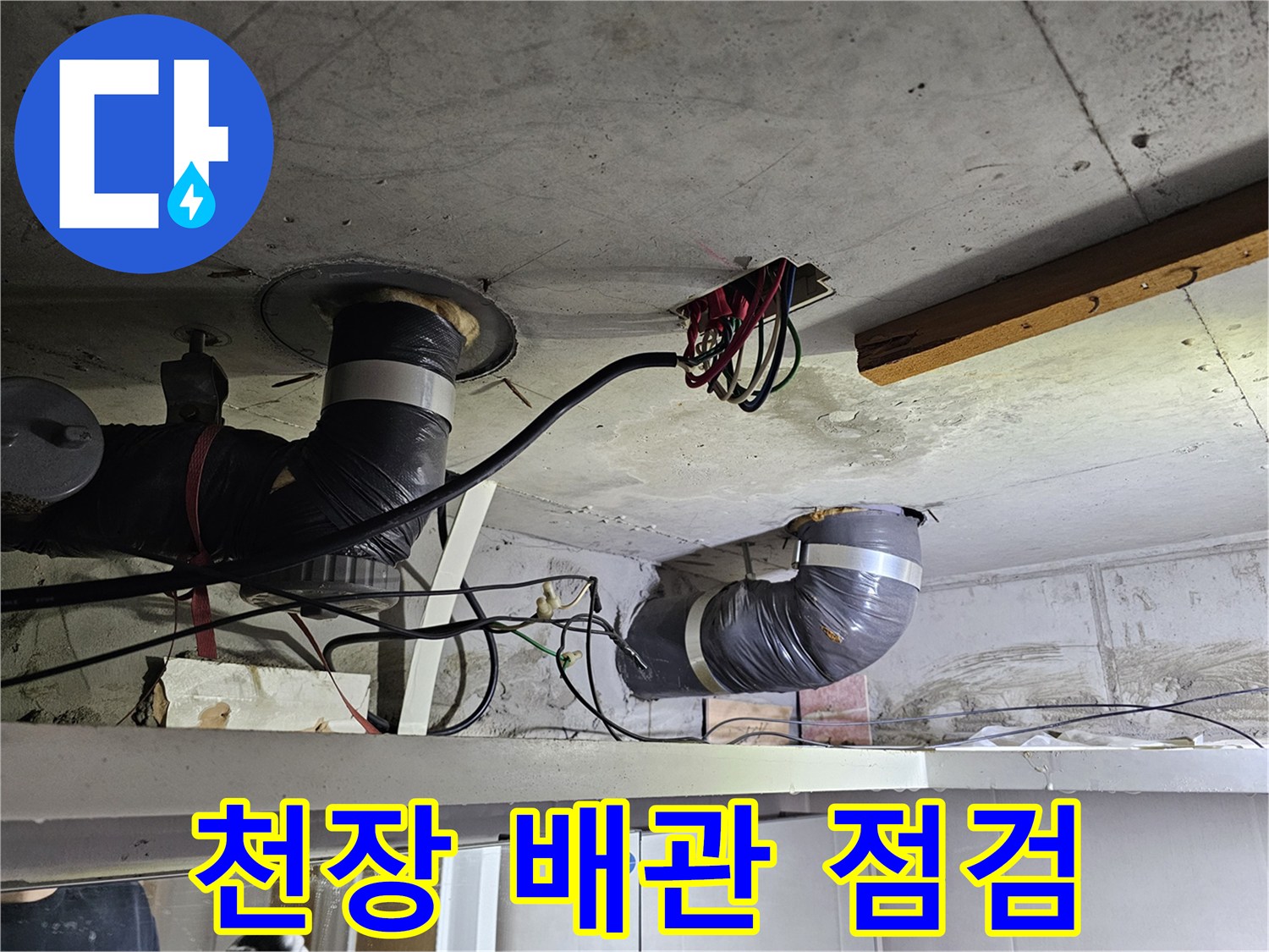 콘크리트 천장 아래-설치된-배관과-전기 배선이-엉켜있는-누수 현장-사진입니다.