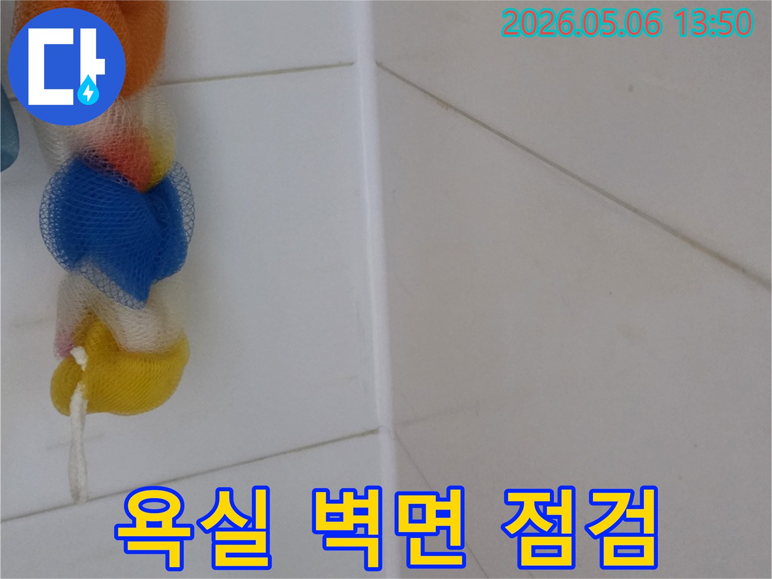 누수 탐지 엔지니어가-욕실 벽면의-타일 상태를-세밀하게 관찰하며-숨겨진 문제점을 찾고 있습니다