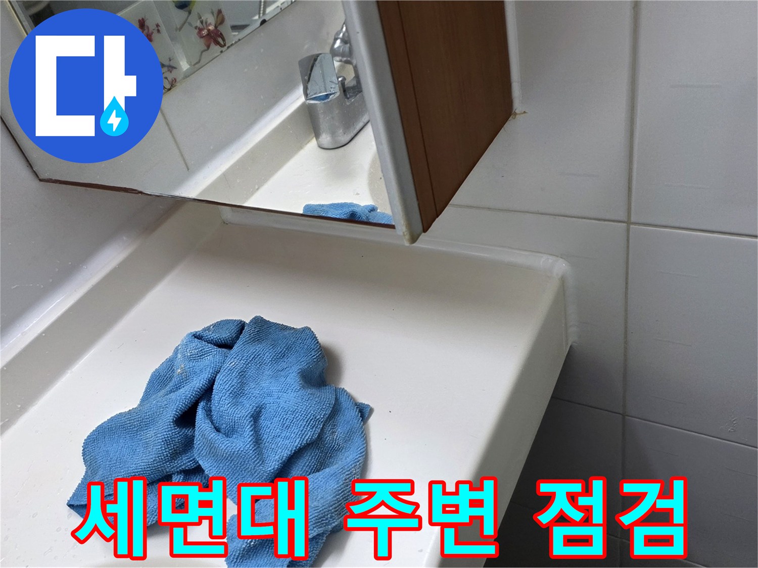 화장실 세면대 하부-파란색 걸레가 놓여 있는 상태