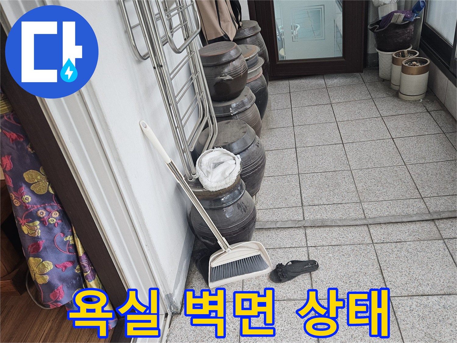 선반 위 용품들과 타일로 마감된 욕실 벽