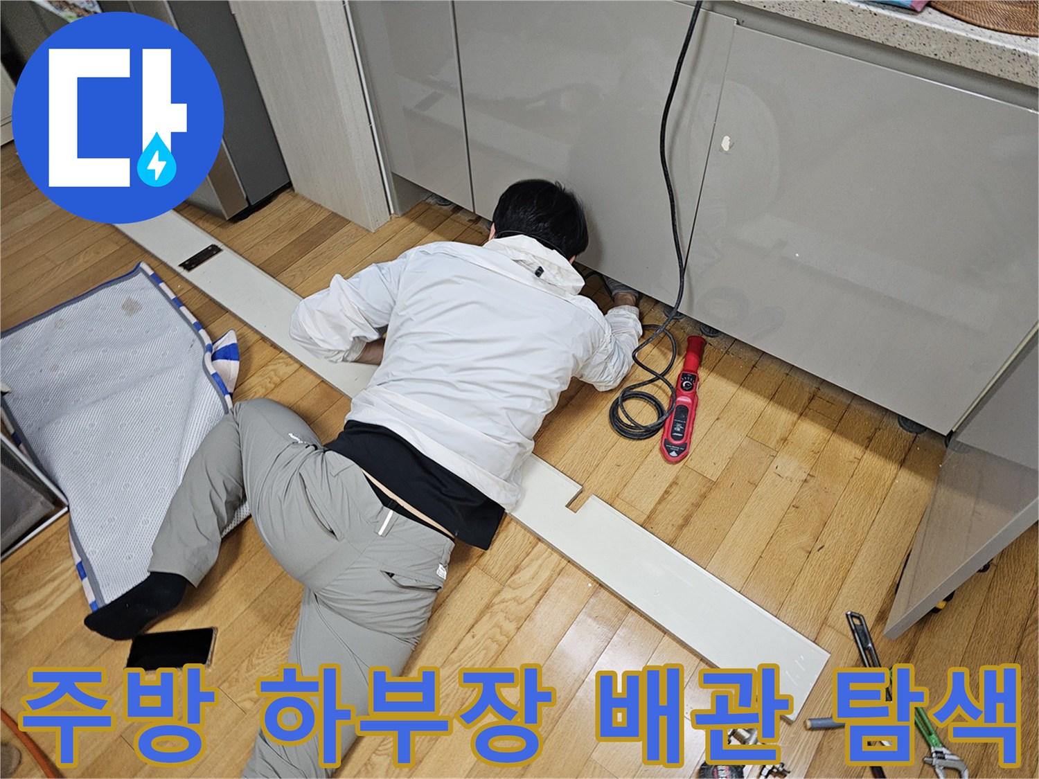 싱크대 아래쪽 좁은 공간에서 배관 상태를 점검하는 엔지니어