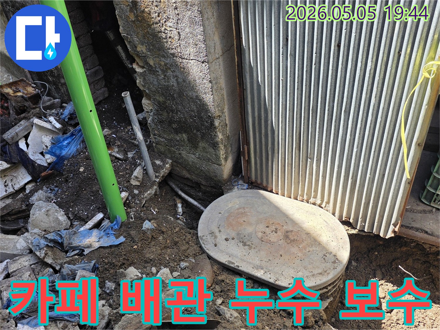 카페 건물 외부에서-발생한 배관 누수 문제를-해결하기 위해-전문가가 현장을-신속하게 보수하는 모습입니다.