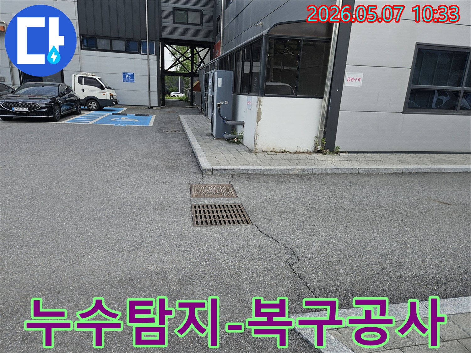 이 이미지는 의정부 만가대길 주차장의 아스팔트 균열과-맨홀-배수구 주변의 지반 문제를 보여주며-누수탐지 후 복구 공사가 필요한 현장입니다.
