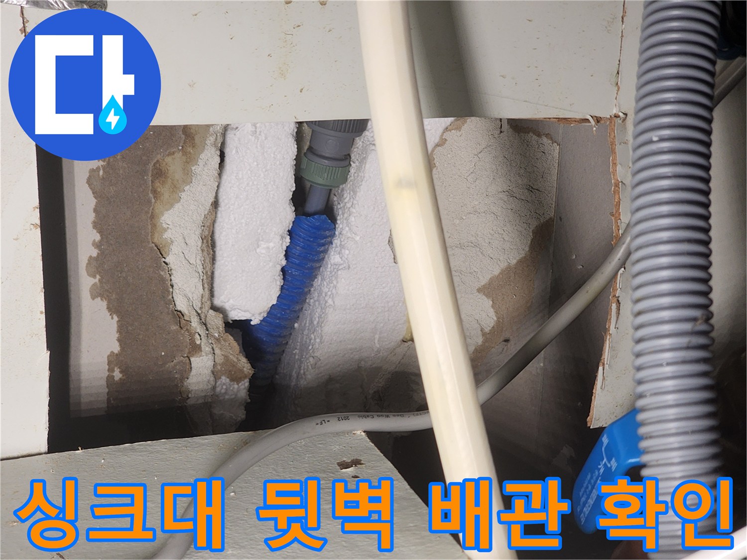 싱크대 하부 뒤쪽 벽면-파란색 온수 배관과 단열재 상태
