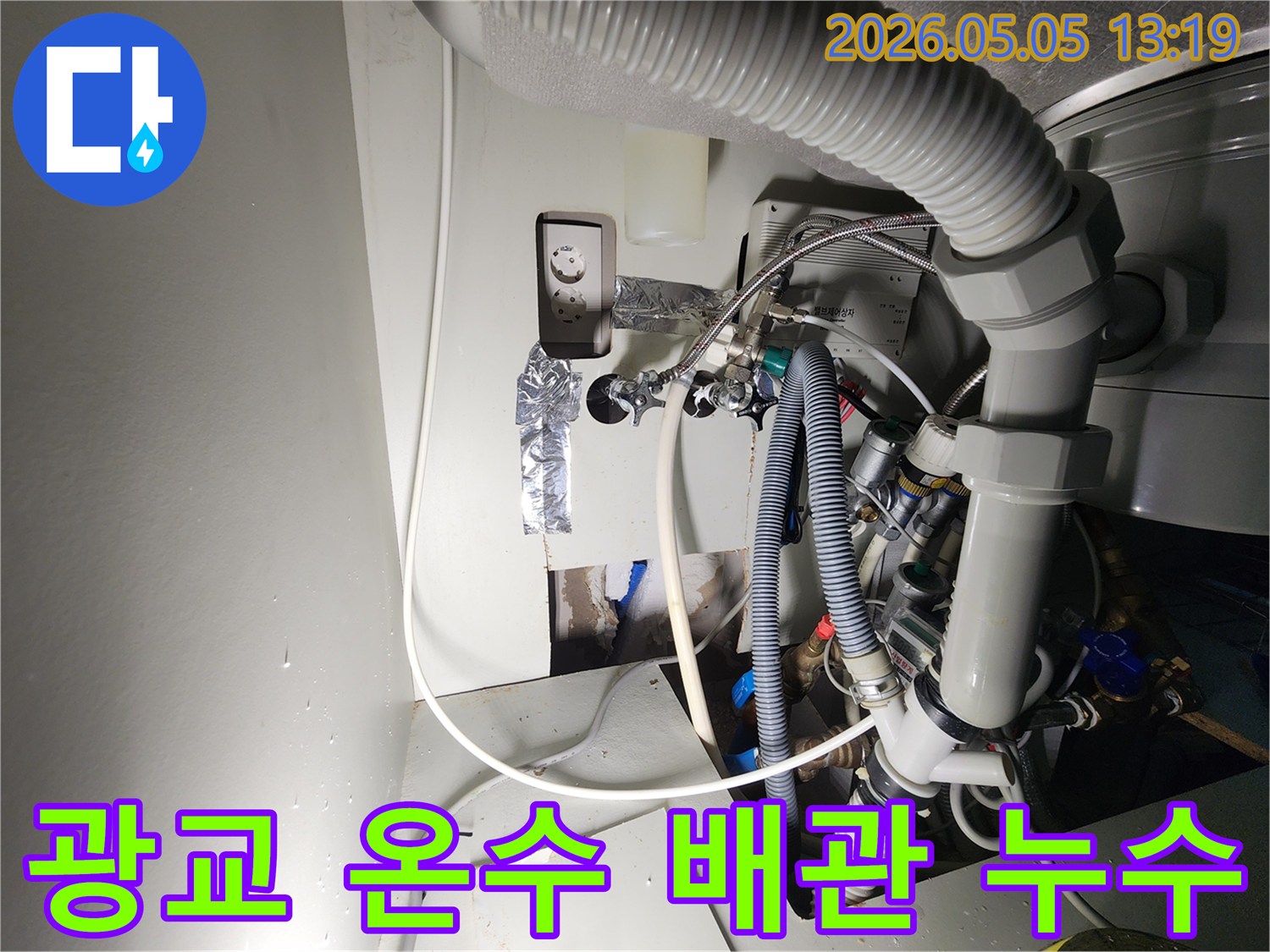 이 이미지는-수지-광교-아파트의-온수-배관-누수-현장을-보여주며-벽면을-개방하여-드러난-손상된-온수-배관과-주변-시설을-촬영한-것입니다