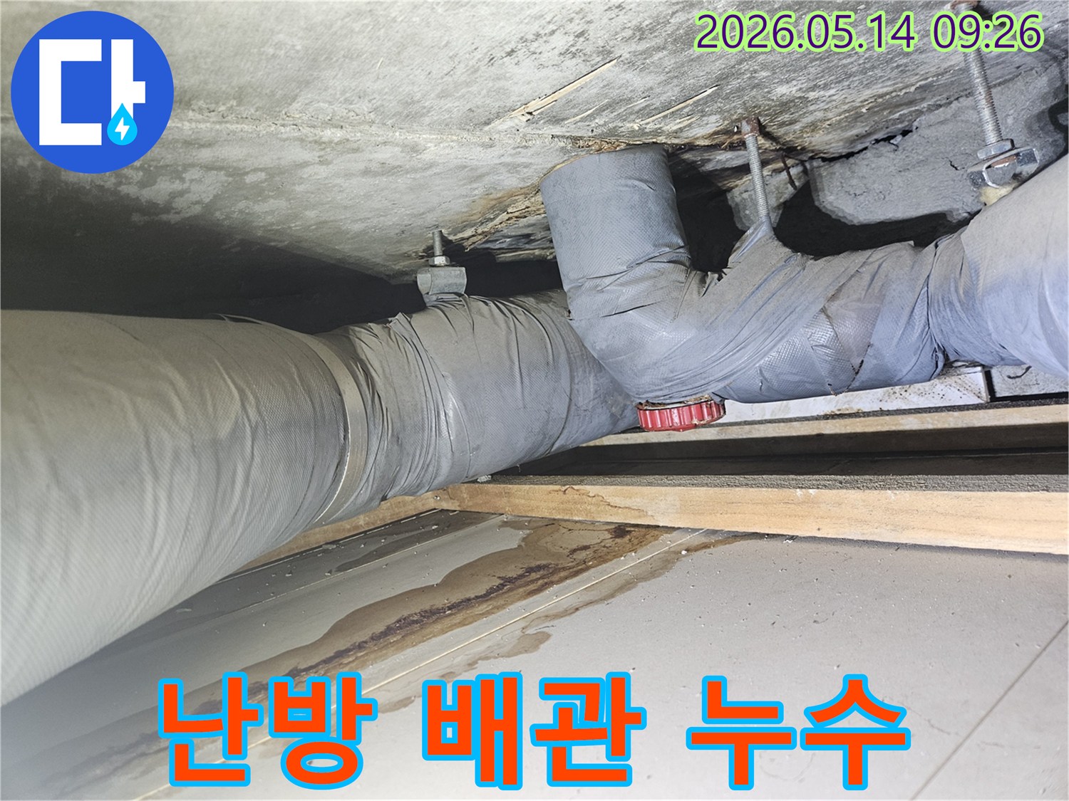 난방 배관 아래 콘크리트 천장에-갈색의 심한 물 자국과 함께 물기가 고인 현장 사진