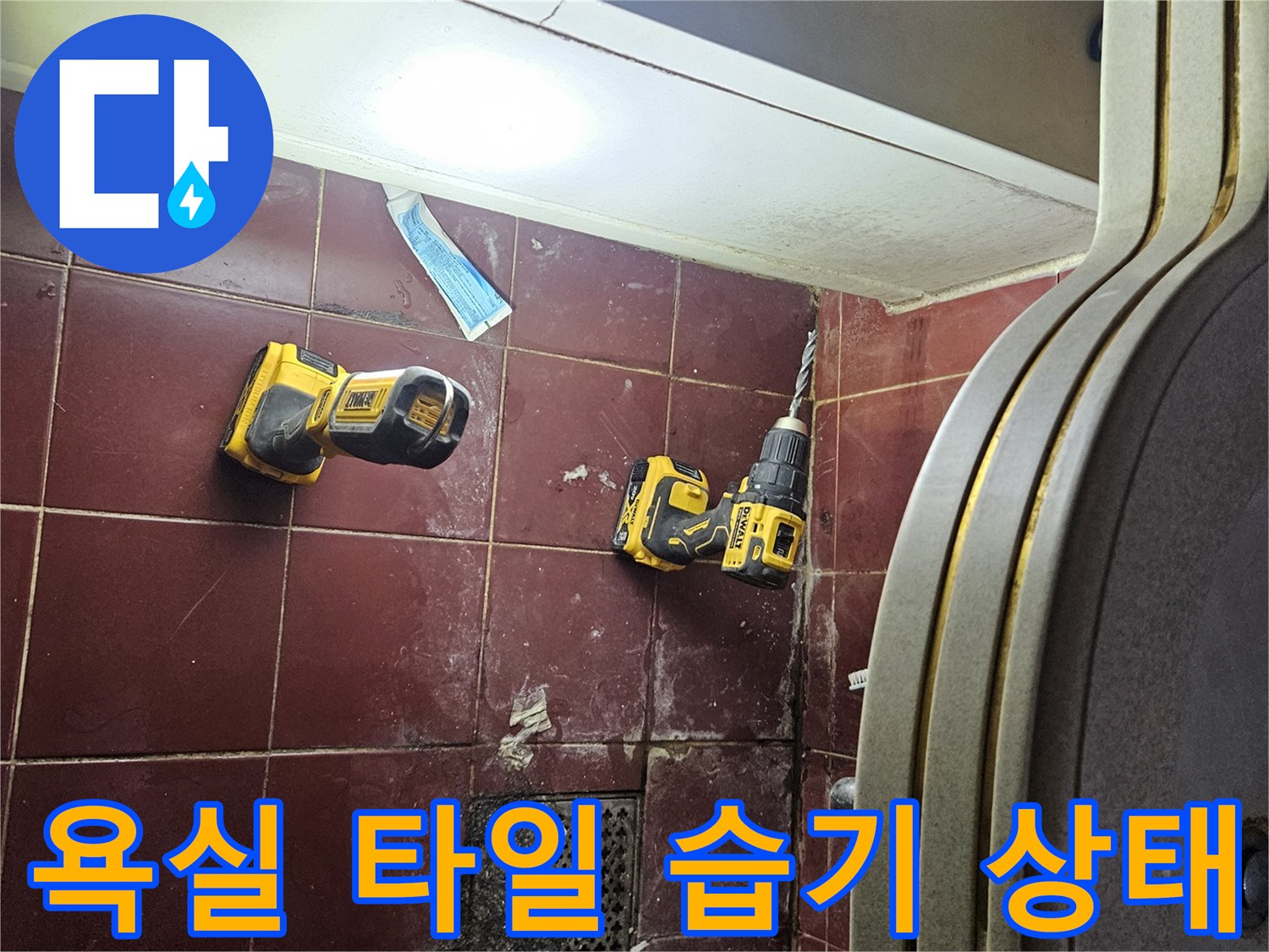 물기가 머금어진 붉은색 욕실 바닥 타일과 장비