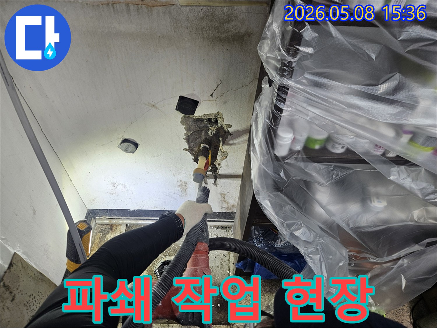 천안 누수 전문 엔지니어가-천장 누수 원인인-배관을 수리하기 위해-파쇄 작업을 진행하며-동시에 먼지 흡입 장비를-사용하는-모습입니다