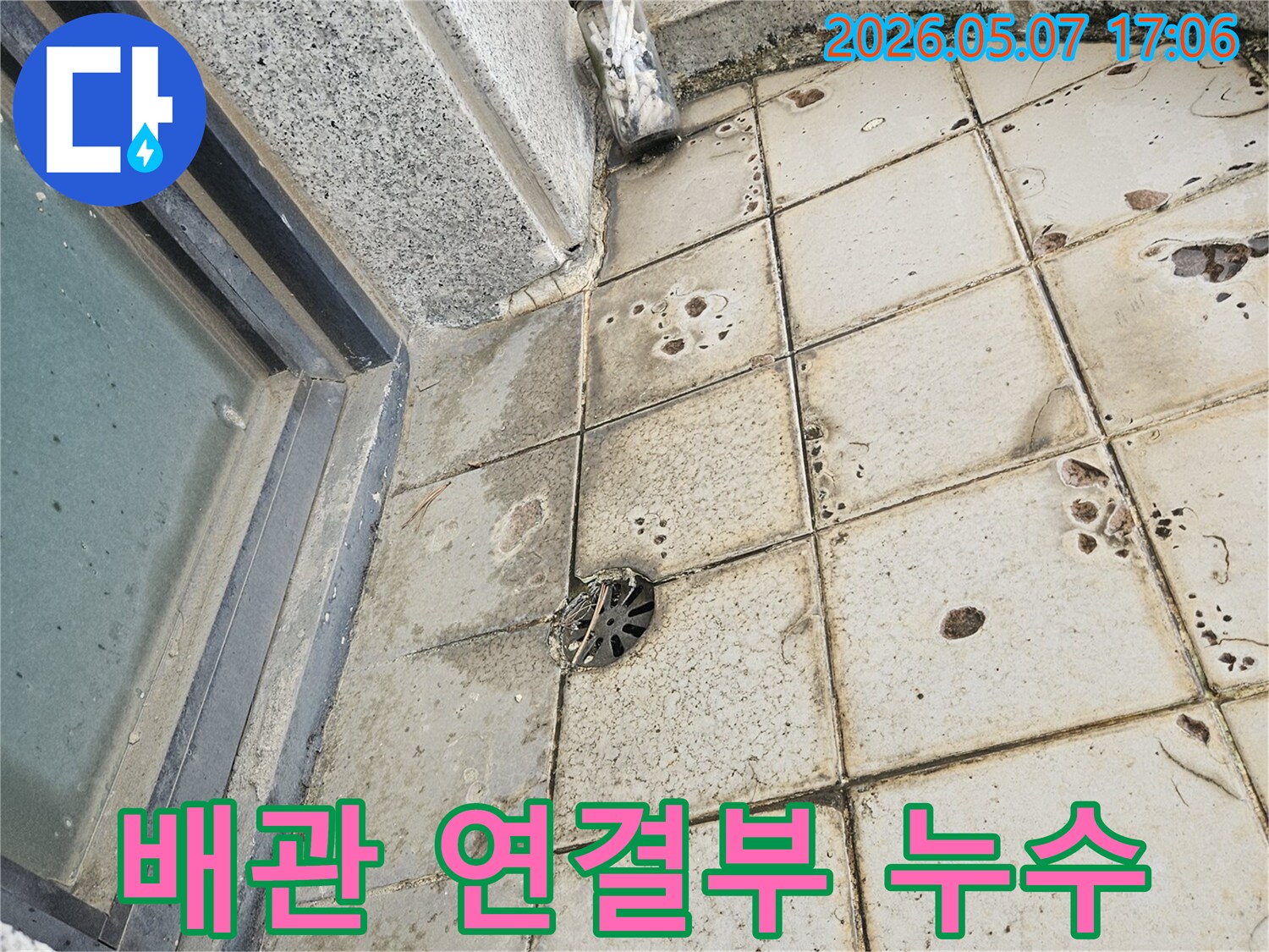 이 이미지는-오래된 배관 연결부에서-누수가 발생하여-주변 타일이 오염된 모습을-자세히 보여줍니다