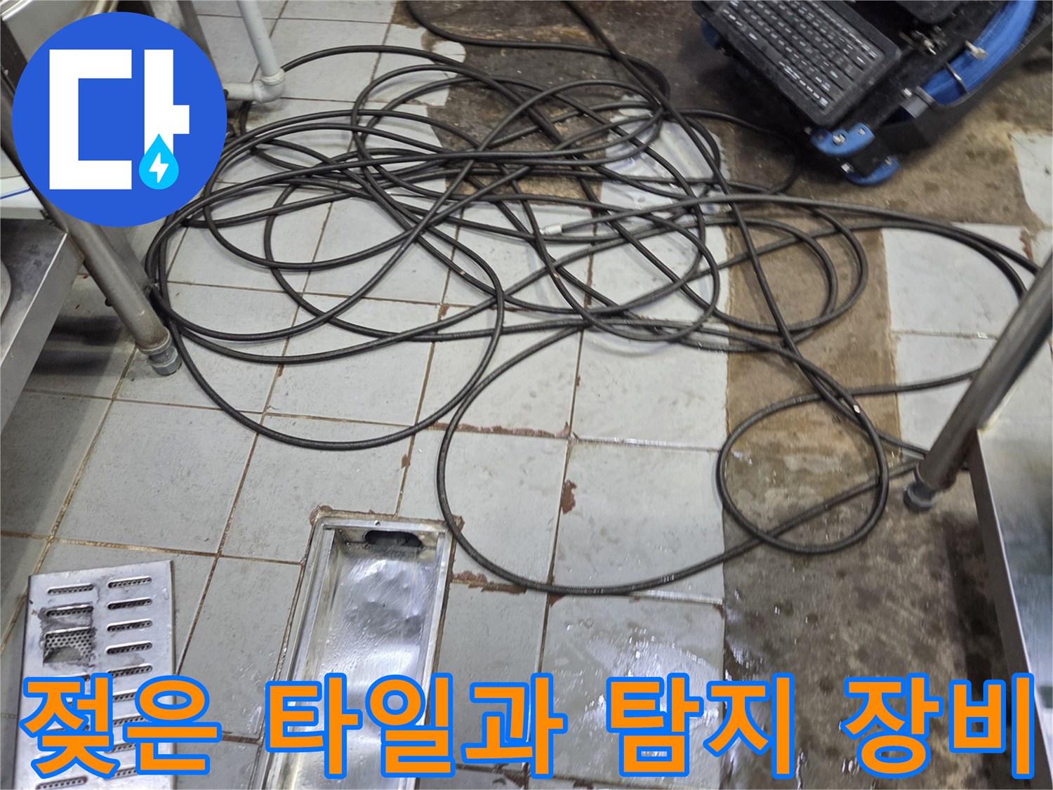 물기가 남아 있는 주방 바닥 타일과 누수 탐색용 장비의 모습