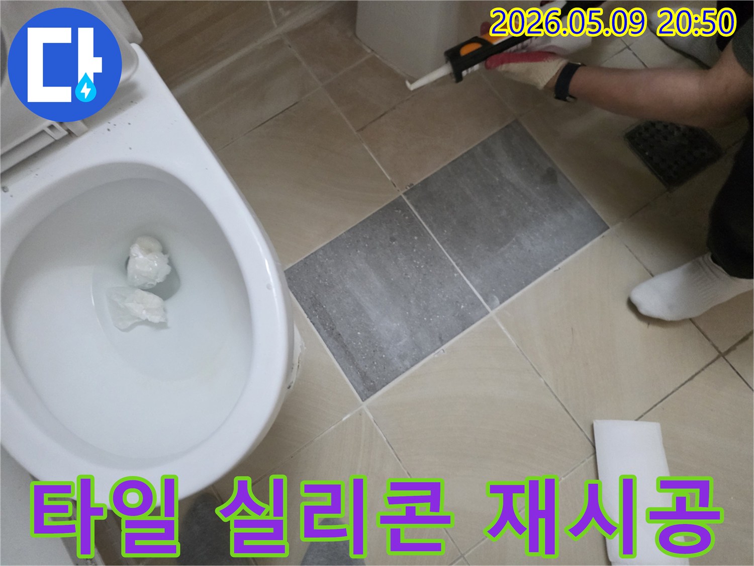 욕실 바닥 타일의-손상된 실리콘을 제거하고-새로운 방수 실리콘으로-재시공하는-전문가의 모습입니다.