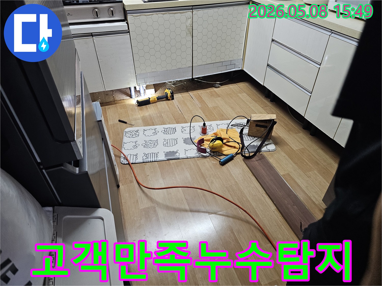 주방 싱크대 하부에서-미세한 누수 원인을-첨단 장비로 정밀하게 탐지하는 모습