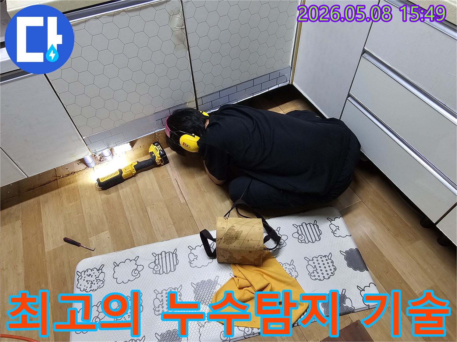 최고의 누수탐지 전문 엔지니어가-정밀한 장비를 사용하여-주방 하부의-누수 지점을 찾아내고 있습니다.