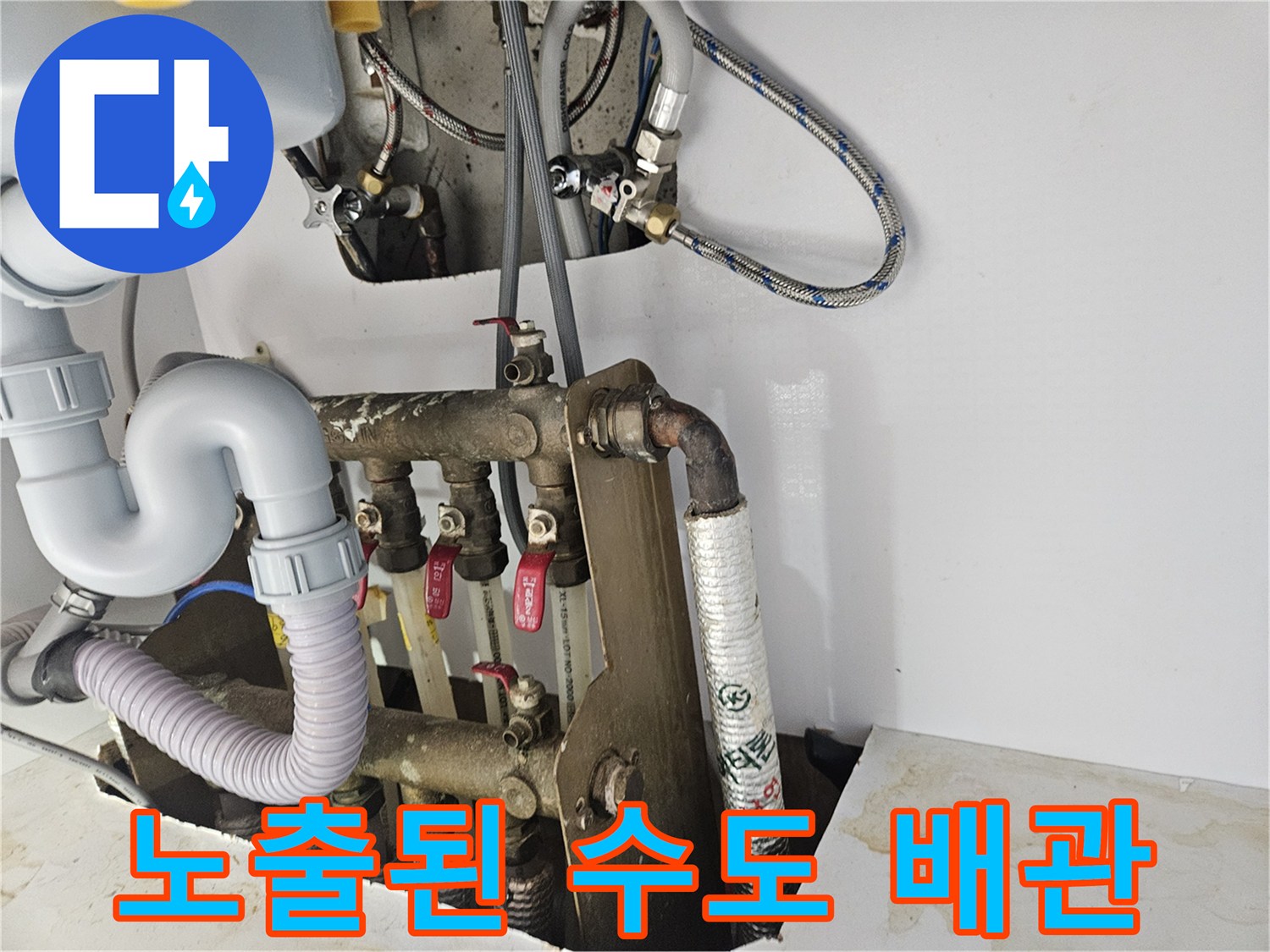 화장실 벽면 하단에 노출되어 연결된 부적절한 배관 구조