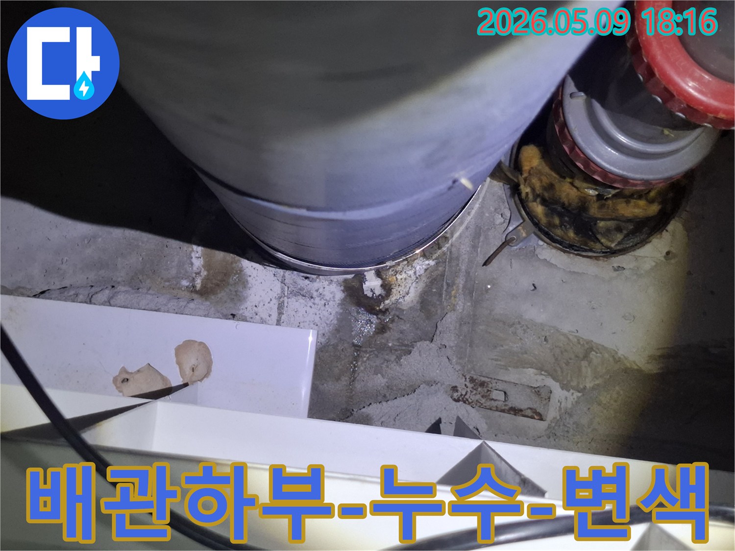 이 이미지는-오래된 배관의-하단부에서-물이 새어-바닥이-변색된-모습을-명확히-보여줍니다