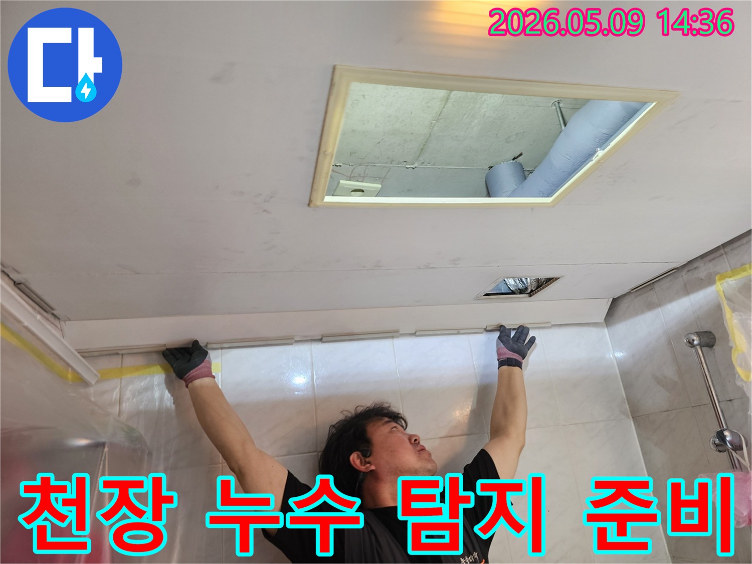 누수 엔지니어가 천장 점검구를 열고-내부 구조를 확인하며-누수 탐지를 준비하는-모습입니다.