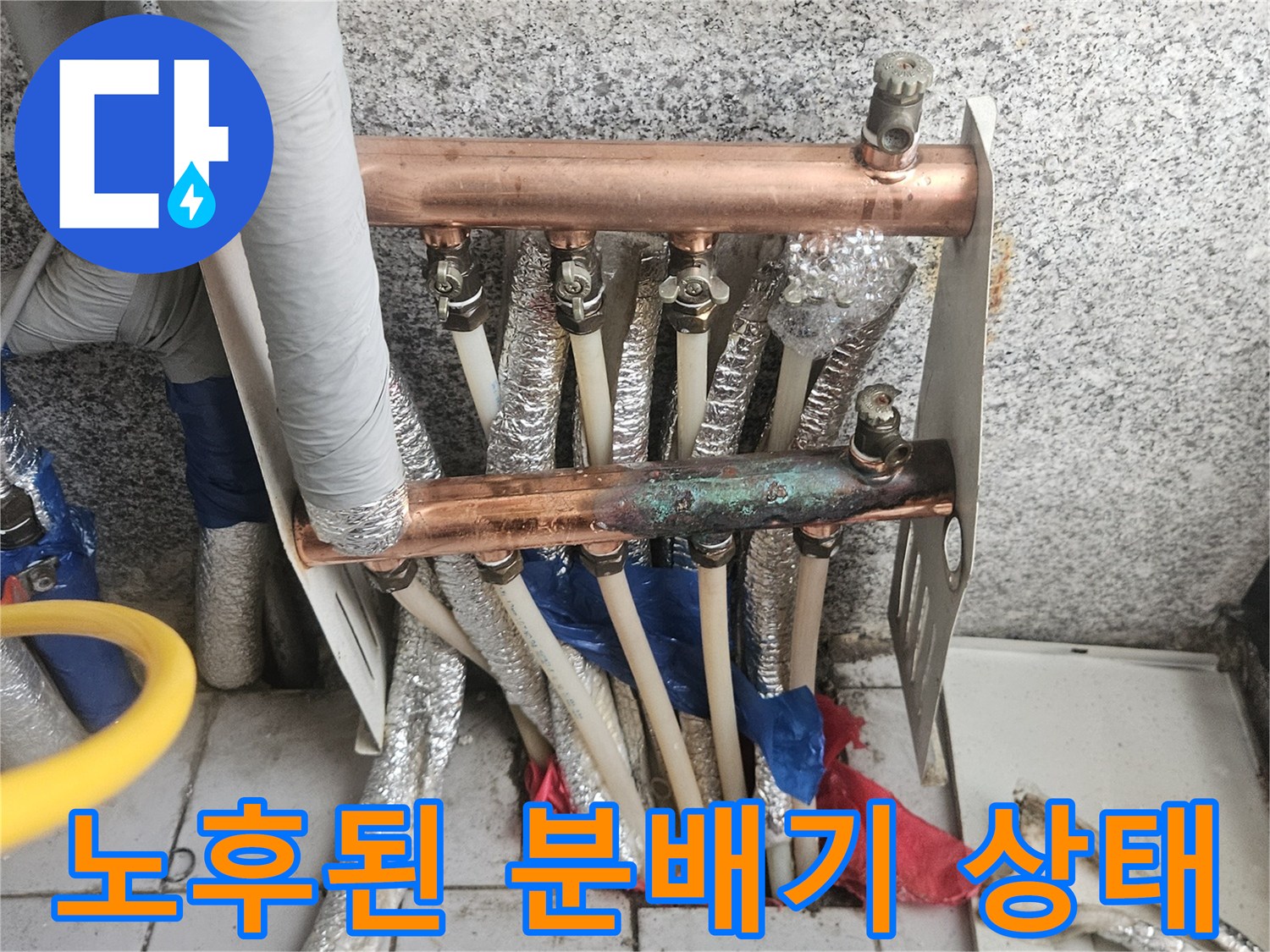 구리색 배관의 부식과 누수 흔적이 보이는 분배기 모습