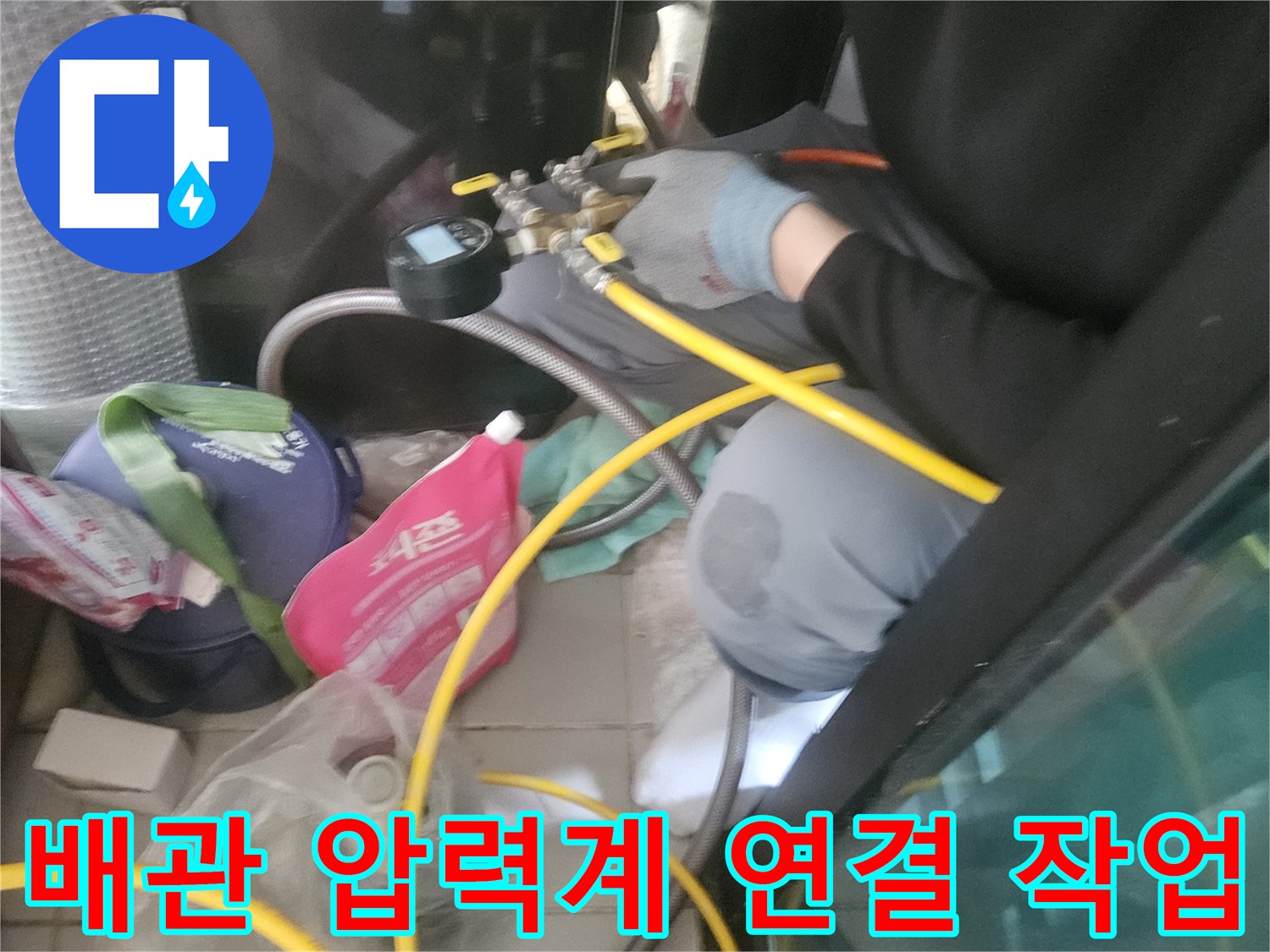 노란색 호스와 장비를 사용하여-배관의 누수 여부를 진단하는 모습입니다.