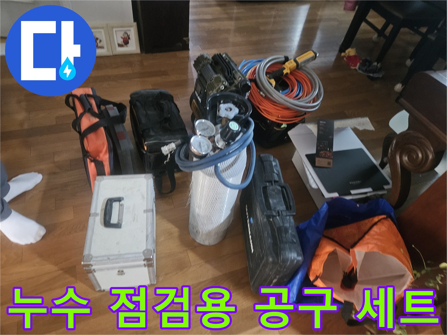 바닥에 놓인 압력계와 배관 부속 및 공구 가방