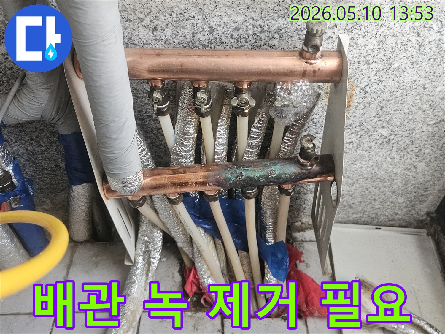 오래된 동파이프 난방 분배기에서-심하게 부식된-녹과 이물질이-배관 청소가 시급함을 보여주는-현장 이미지입니다.