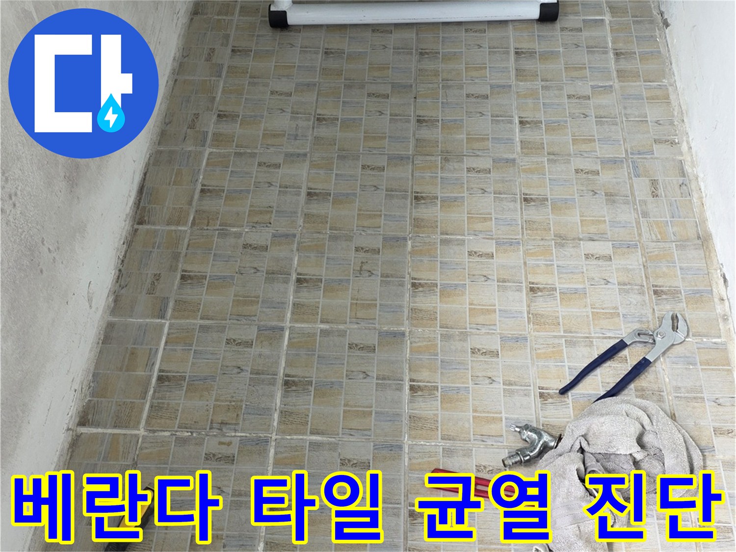 작업 도구가 놓인 베란다 타일 벽면의 점검 중인 모습입니다.