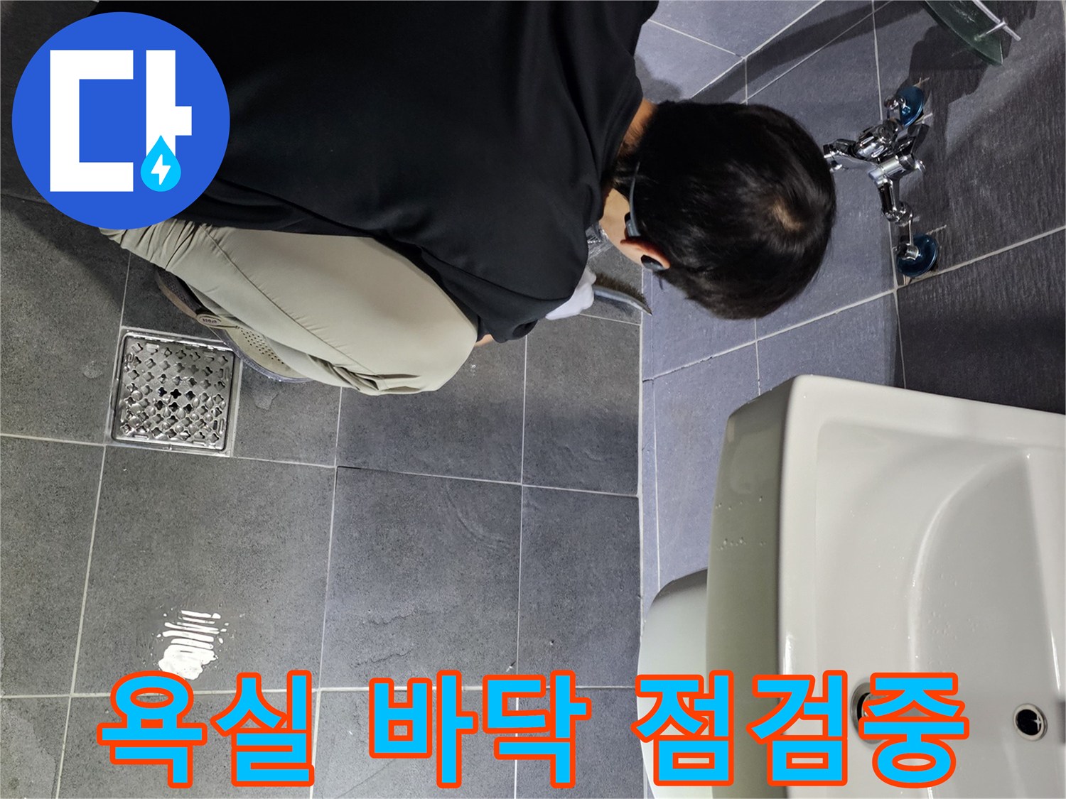 바닥 타일 틈새를 통해 배수구 상태를 체크하는 모습