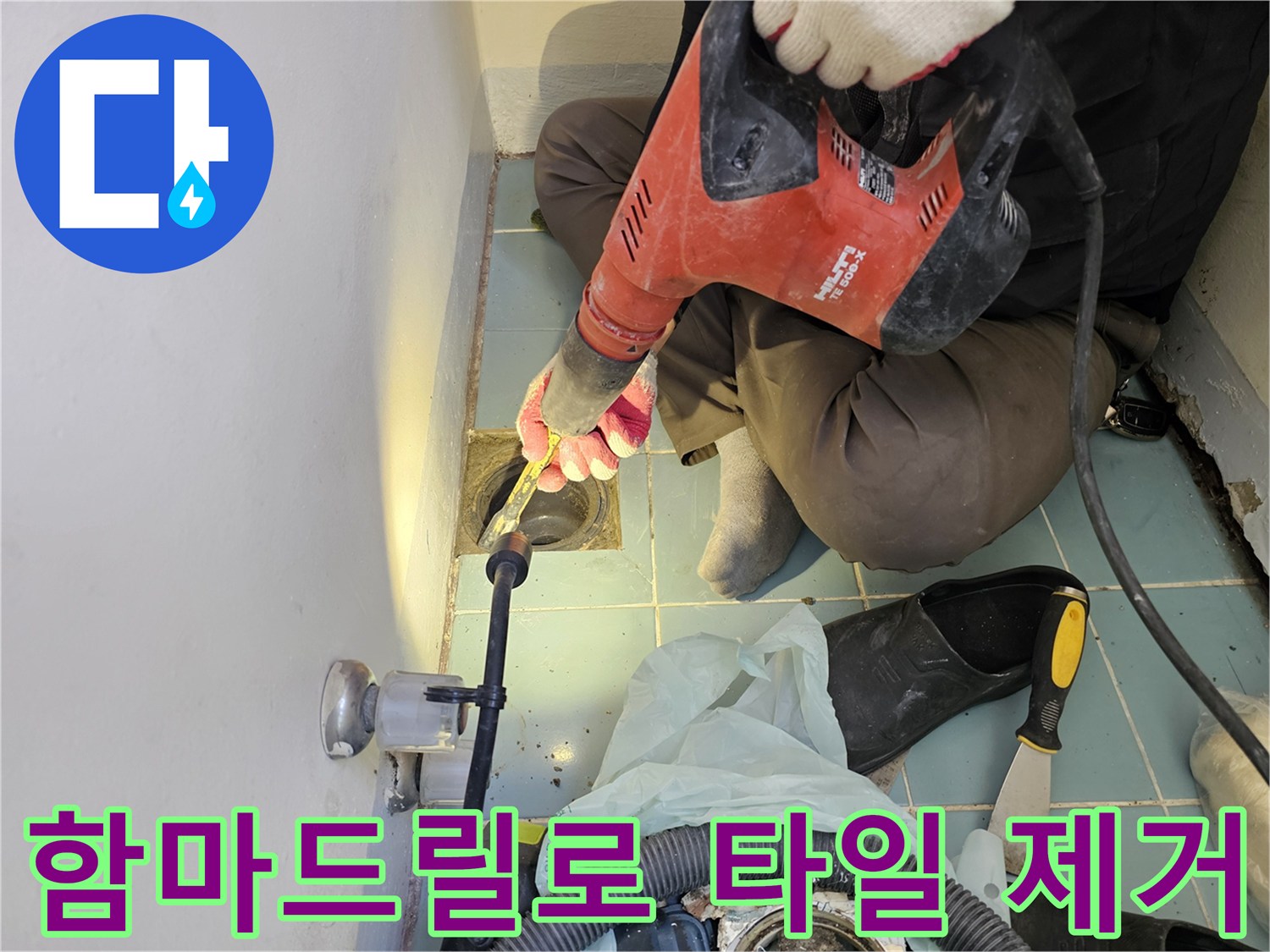함마드릴을 사용하여-배수구 주변의 노후된 타일을 파쇄하는 모습