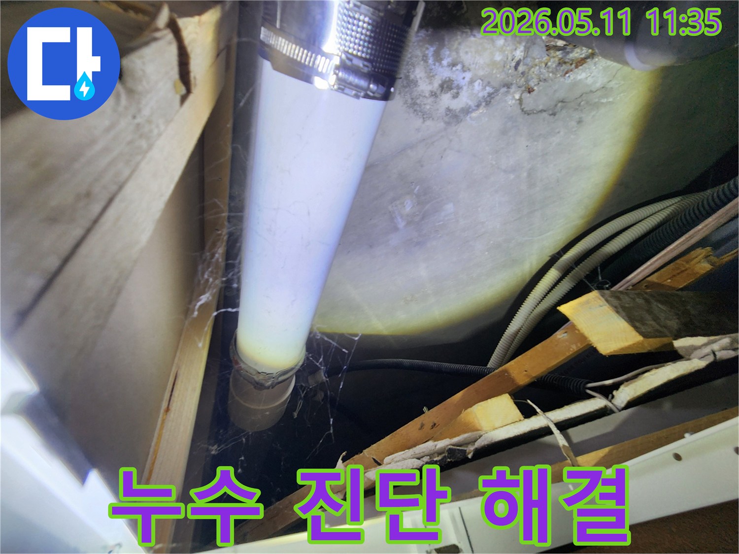 배관의 금속 클램프 주변에서-발견된 미세한 물샘 흔적을-확대하여 보여주는 이미지입니다.