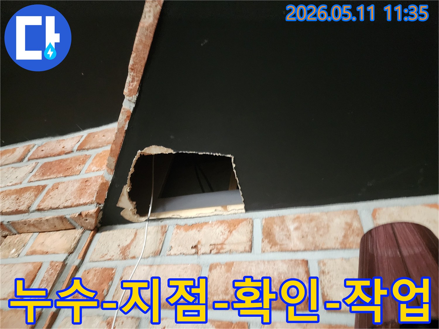 천장 누수 원인을 육안으로 확인하기 위해 벽돌 벽 옆 천장 일부를 개방한 모습입니다.