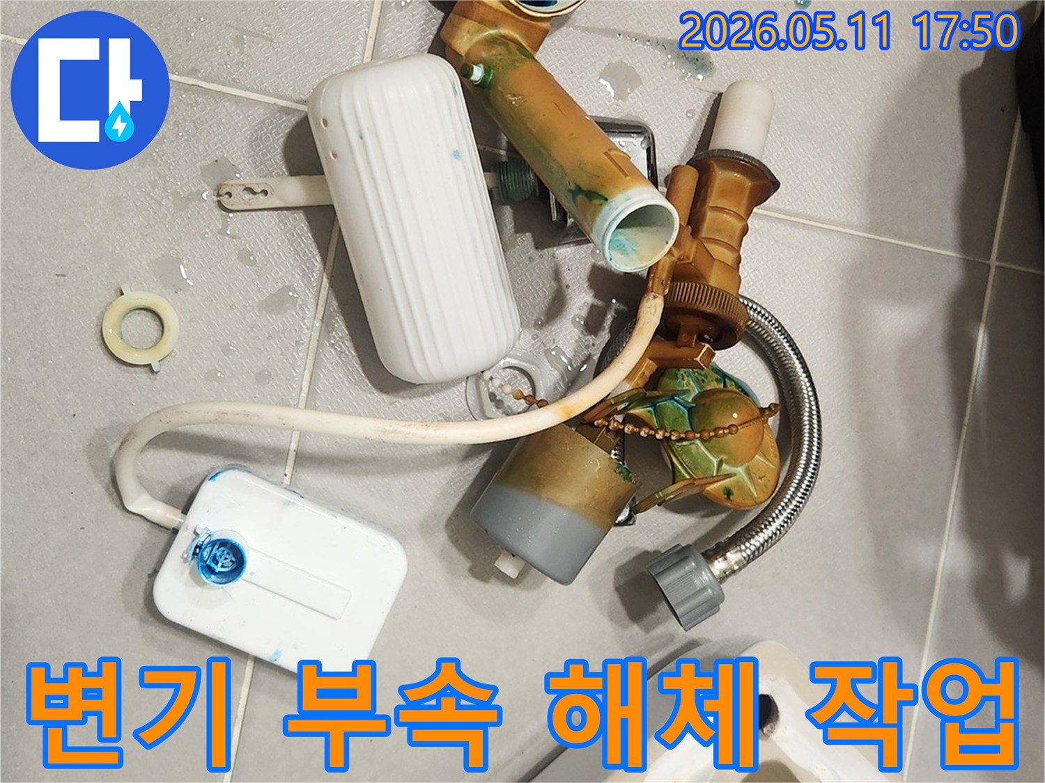 안방 변기에서 발생한 물샘 문제를 해결하기 위해-오래된 변기 부속들이 해체되어 바닥에 놓여 있는 모습입니다-새 부품으로 교체하여 변기를 수리할 예정입니다