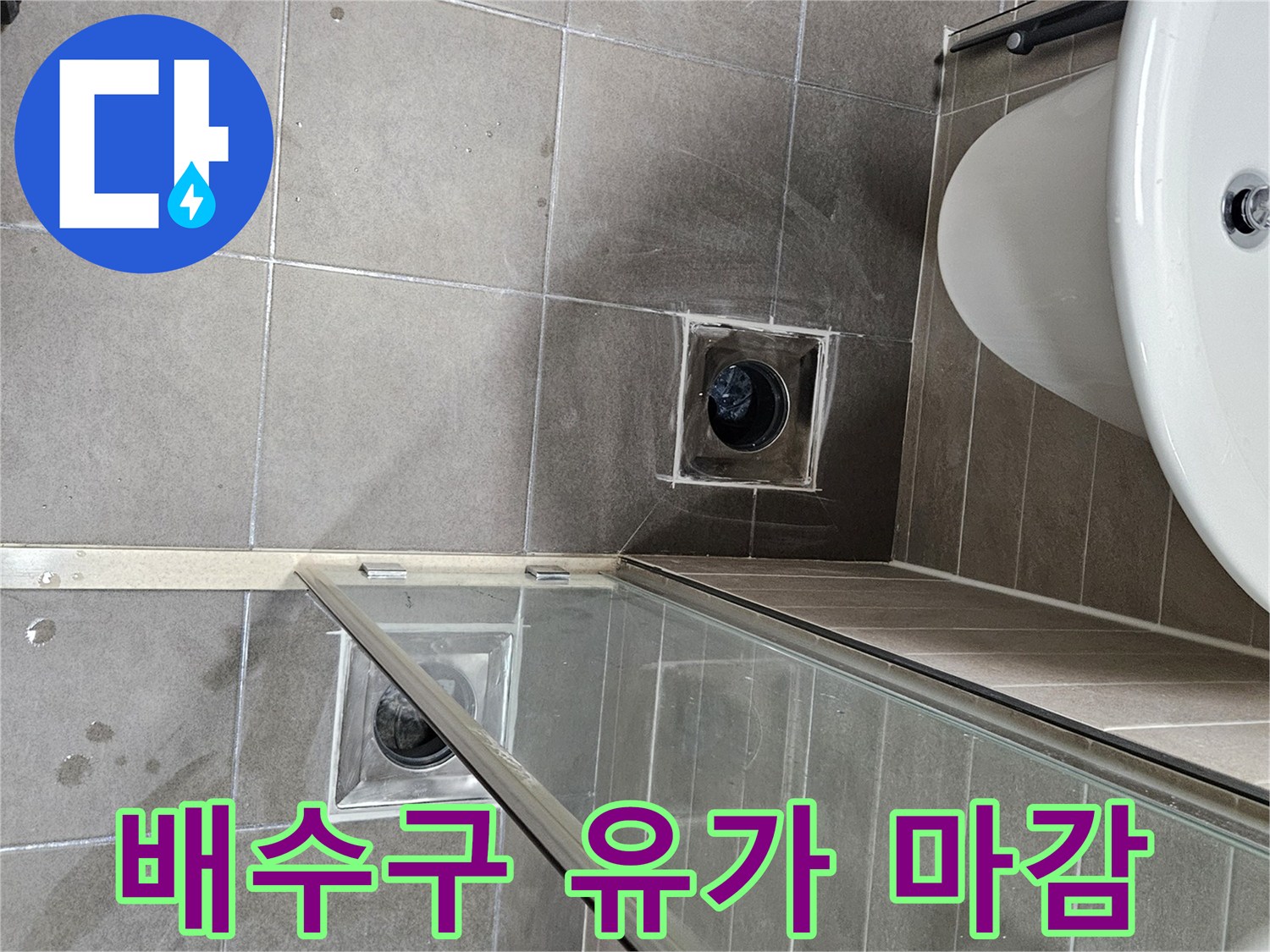 세면대 하단 배수구 주변 타일 및 유가 근접 사진