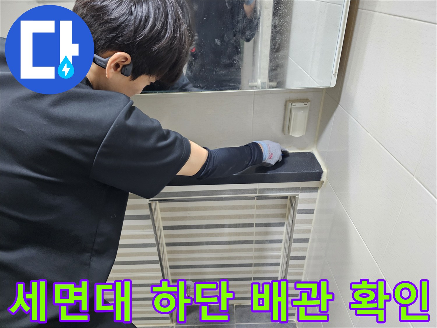 세면대 하부 트랩 및 연결 배관의 부식 상태를 점검하는 엔지니어
