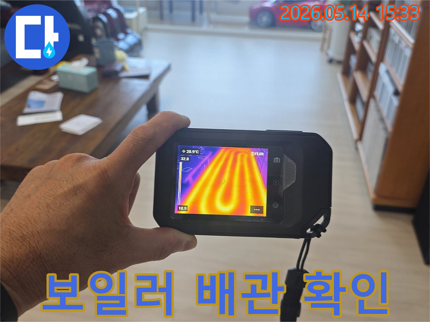 이 이미지는-누수 탐지 전문가가-열화상 카메라를 사용하여-바닥 아래 난방 배관의-온도 변화를 확인하는-모습을 보여줍니다