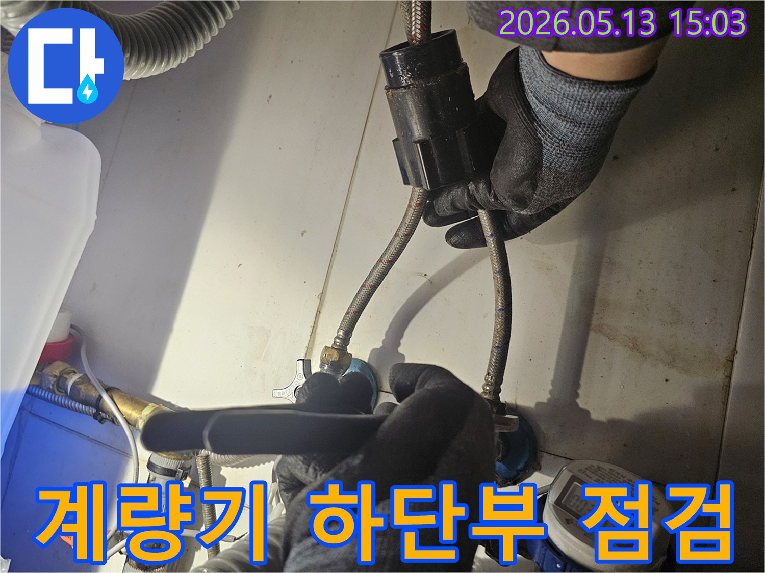 전문 엔지니어가-수도 계량기 하단의-배관 연결 상태를-면밀히 확인하고 있습니다
