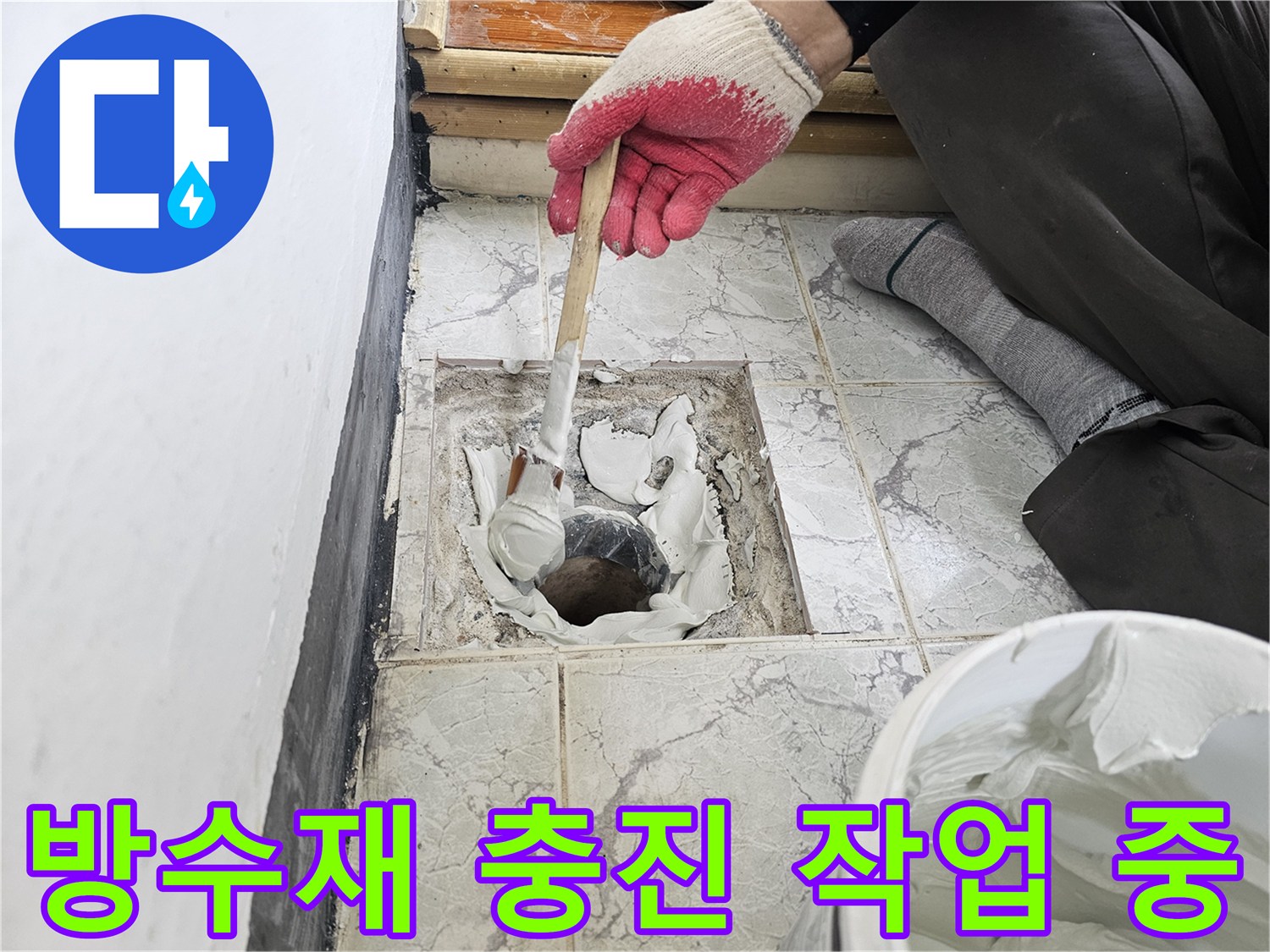 백색 방수제를 사용하여 배관 주변의 빈 공간을 메우고 있습니다.