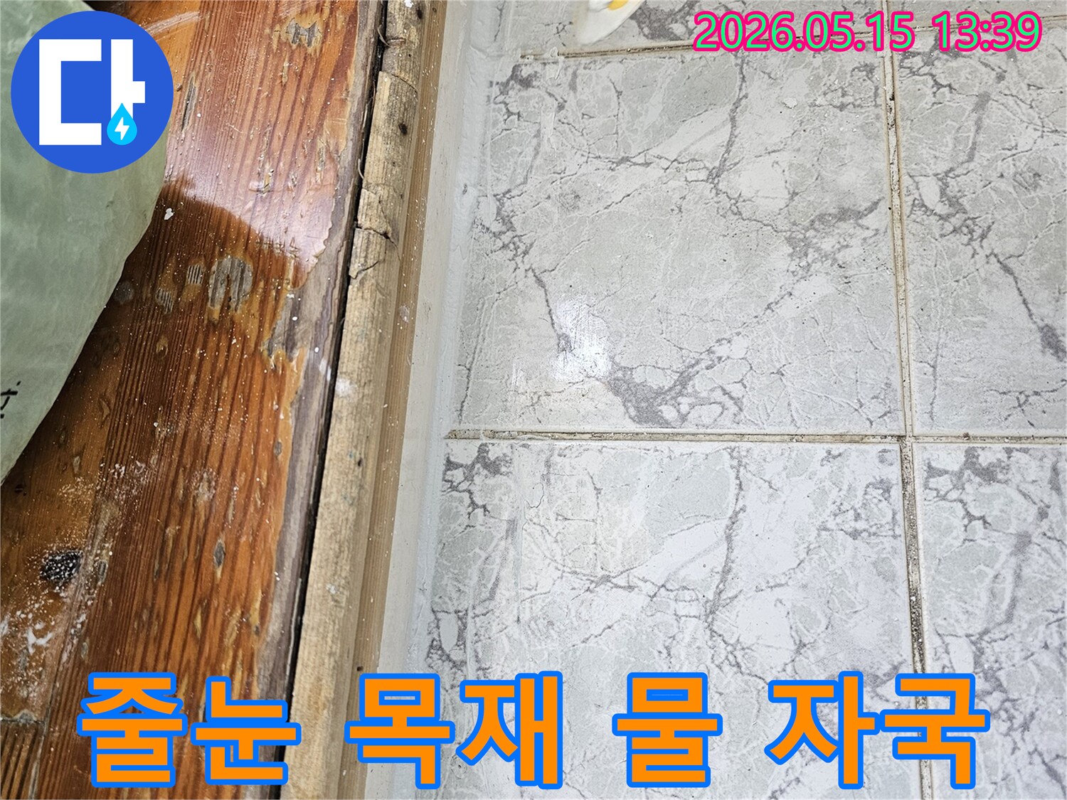 이 이미지는-의정부 신곡동 아파트에서 발견된-타일 줄눈과 목재 마감재에 나타난-물 자국으로 누수가 의심되는 상황을 보여줍니다