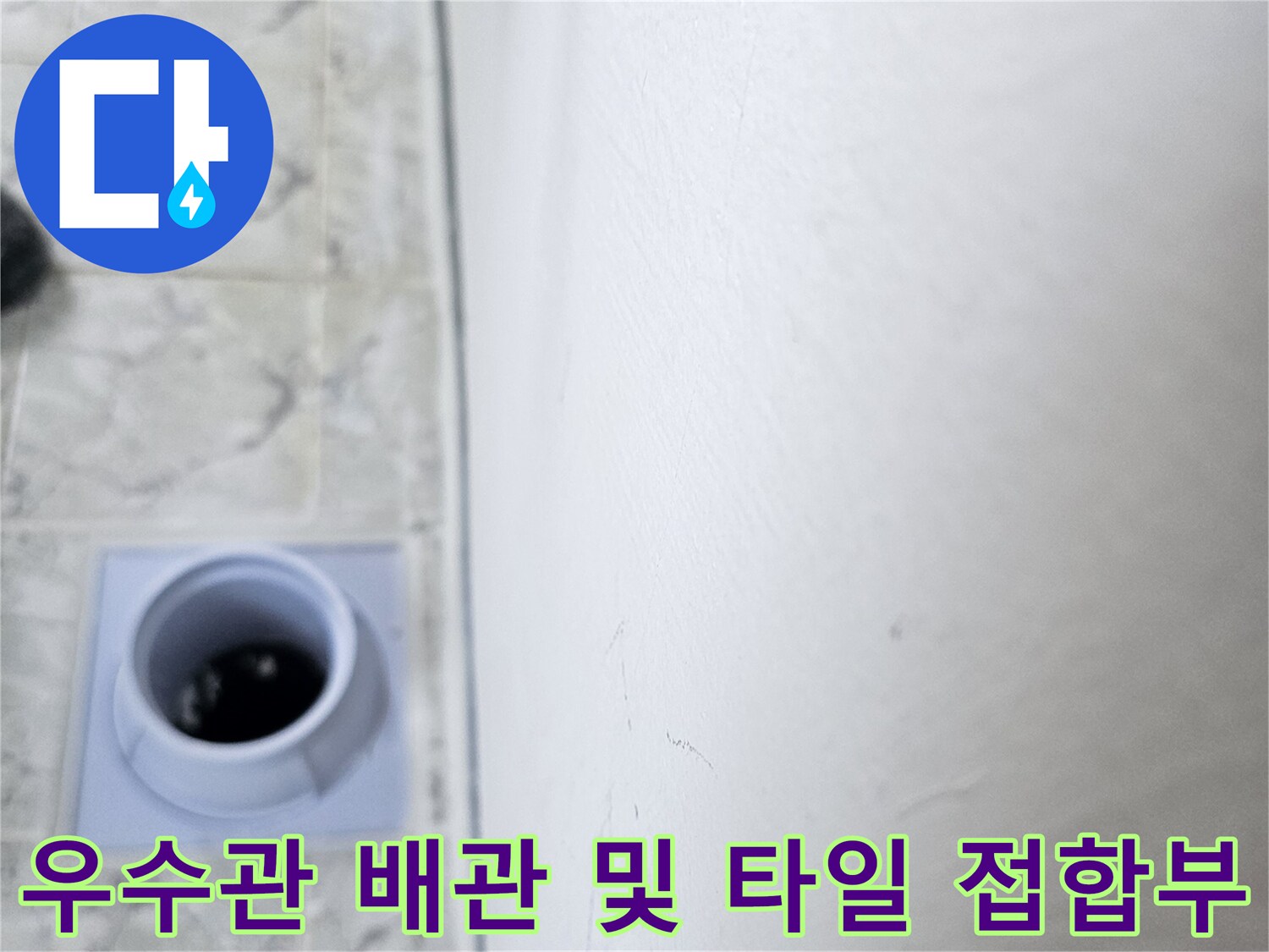 하얀색 배관과 무늬가 있는 바닥 타일이 만나는 지점