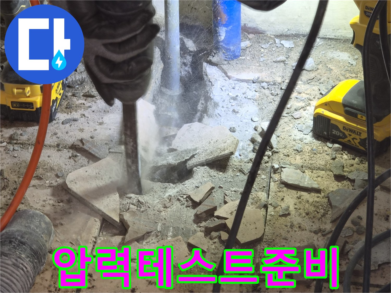 작업자가-바닥을-파쇄한-후-드러난-배관에-압력-테스트-장비를-연결하여-누수-여부를-재확인하는-준비-과정을-보여주는-사진입니다.
