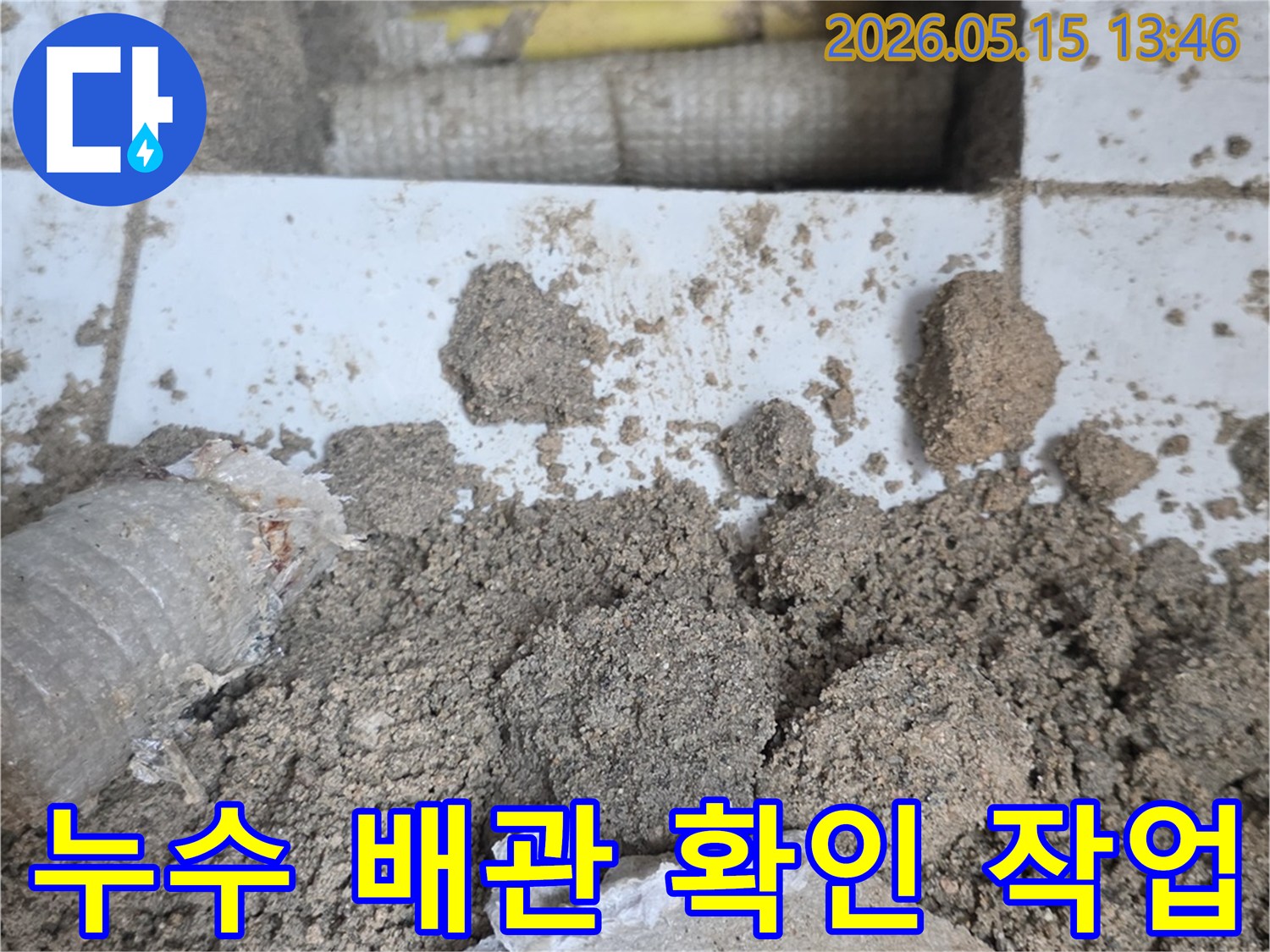 누수 탐지 과정에서-바닥을 개방하여-노출된 배관과-주변의 흙-그리고-파손된 자재들이-보이는-장면입니다