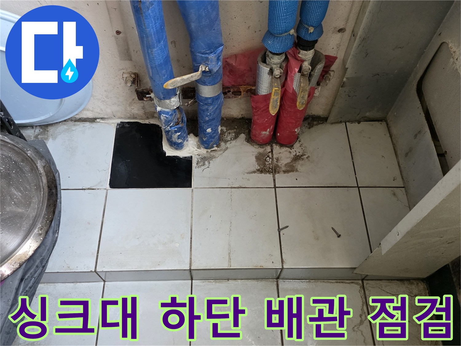 주방 싱크대 밑 분배기와 연결된 파란색 및 빨간색 주름관의 상태를 확인하는 모습입니다.