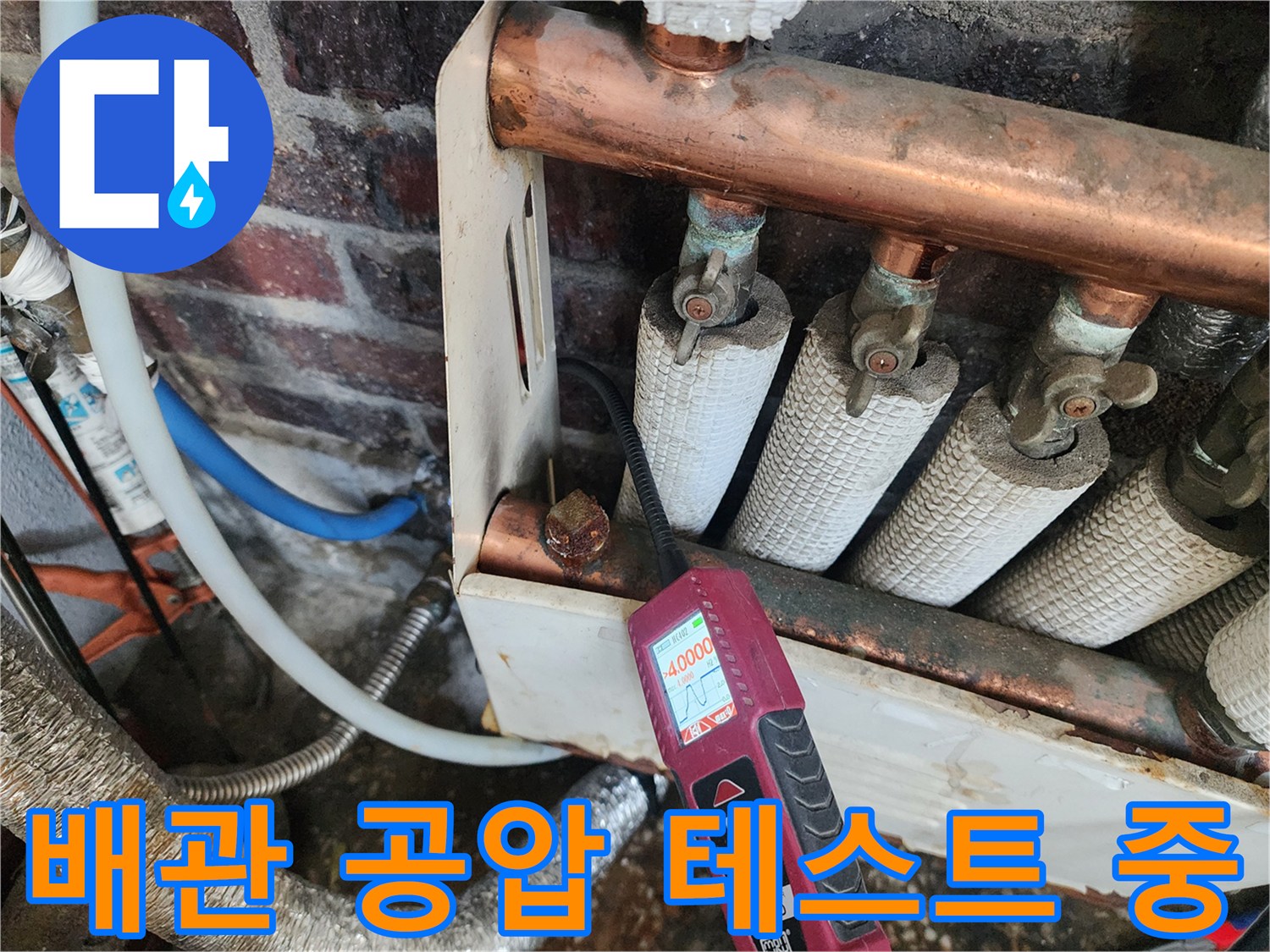 구리 소재의 분배기 배관에 압력을 걸어 측정하는 현장 사진입니다.